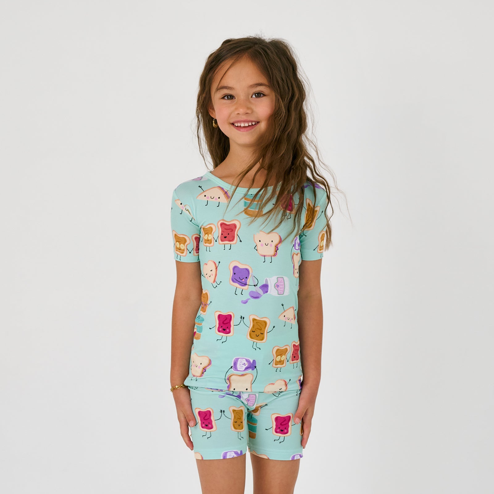 Close up of standing child wearing the Lunch Buddies Two-Piece Short Sleeve & Shorts Pajama Set