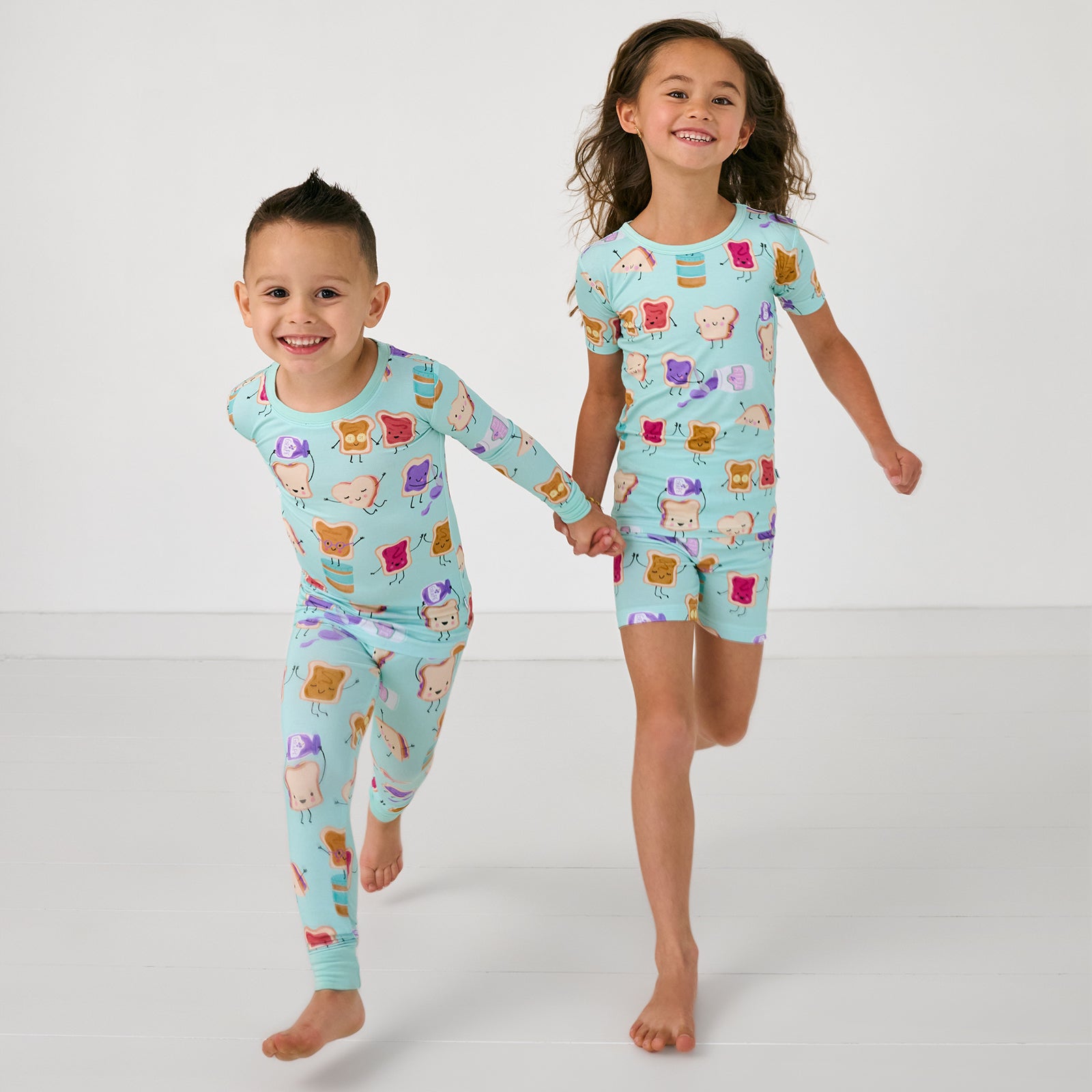 Two running children wearing matching Lunch Buddies Two-Piece kids PJ sets