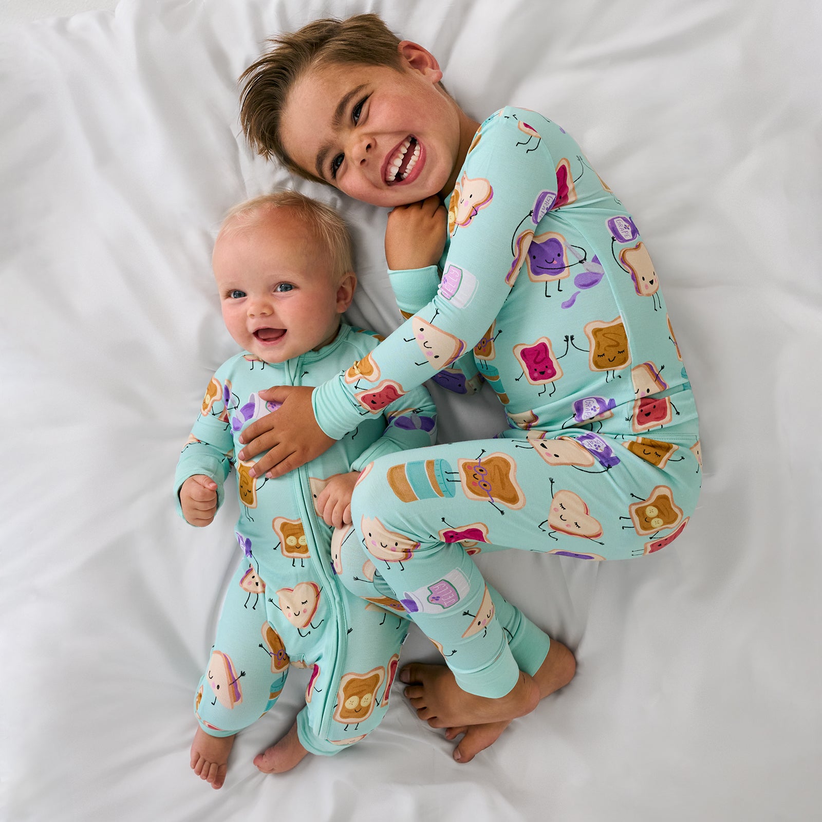 Aerial view of two children wearing matching Lunch Buddies Bamboo kids pajamas