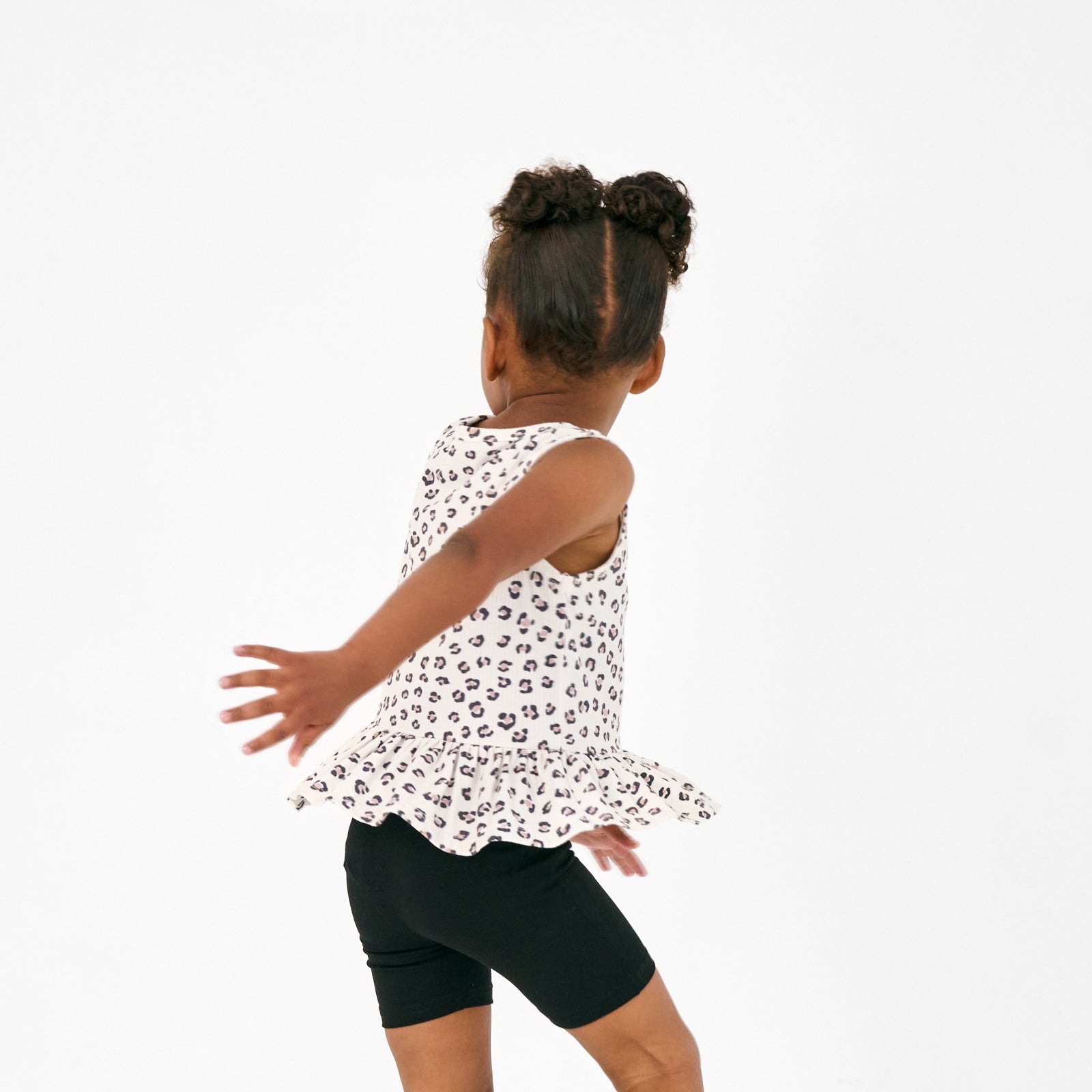 Child in motion wearing the Luxe Leopard Peplum Tank