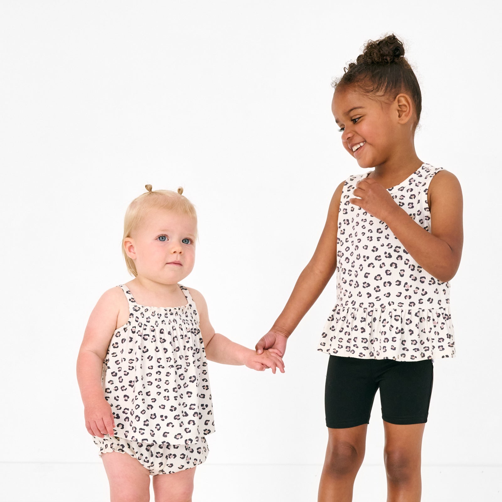 Two children wearing matching Luxe Leopard play styles