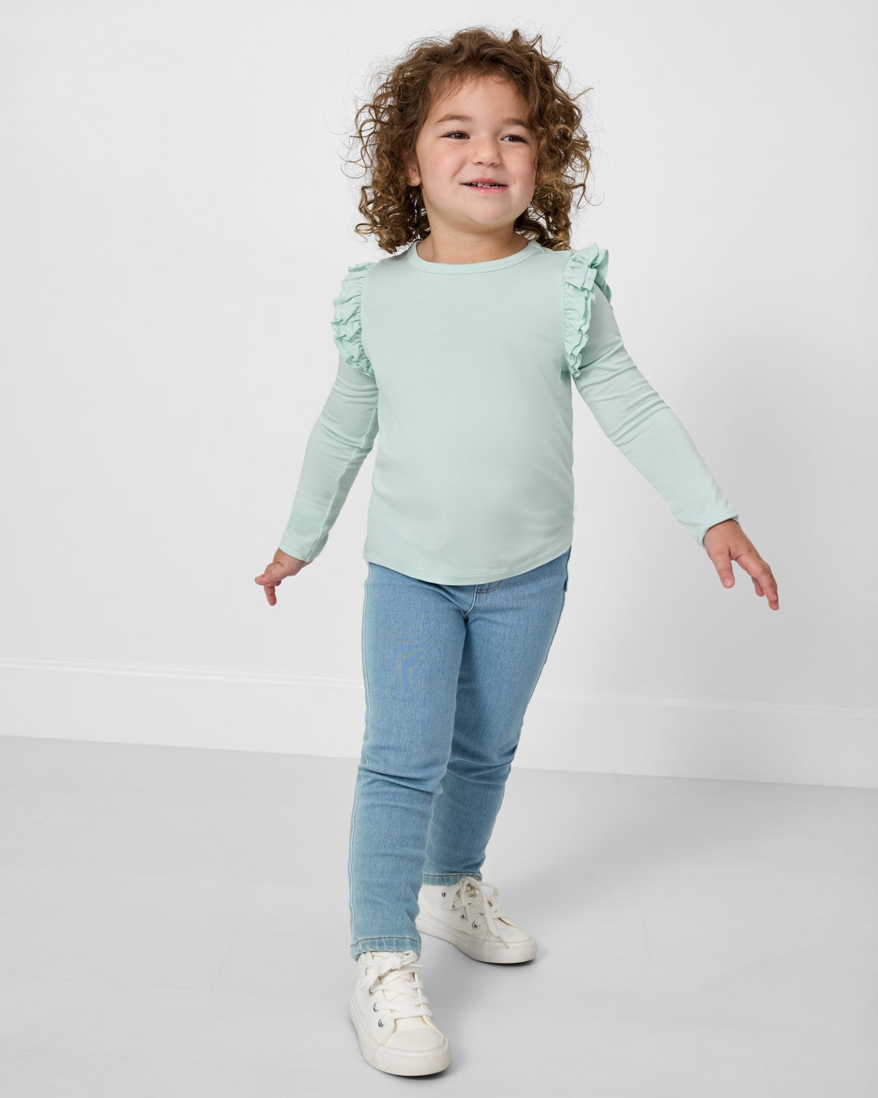 Girl wearing the Mint Mist Flutter Tee and Jeans