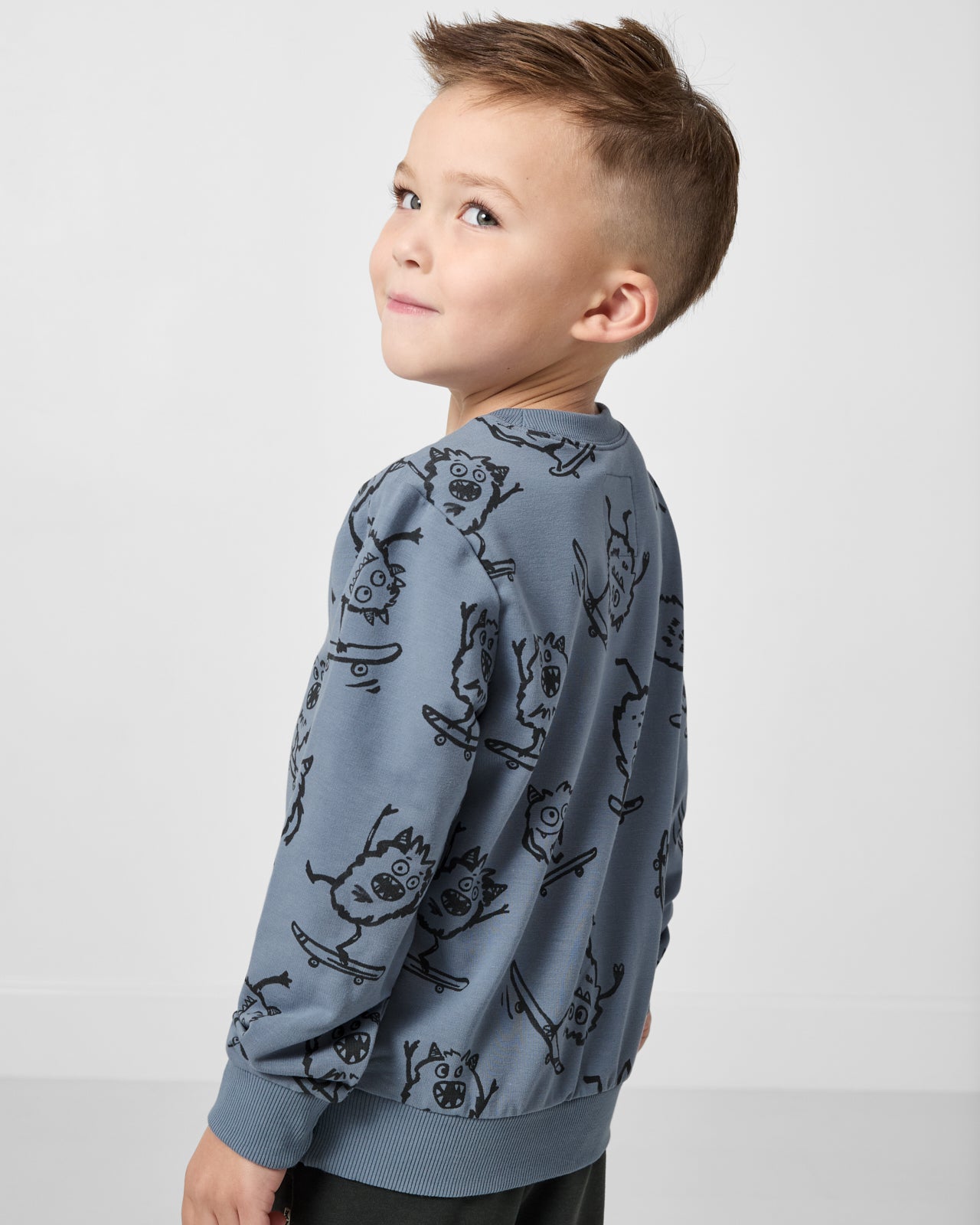 Back view of boy wearing the Monster Moves Crewneck Sweatshirt