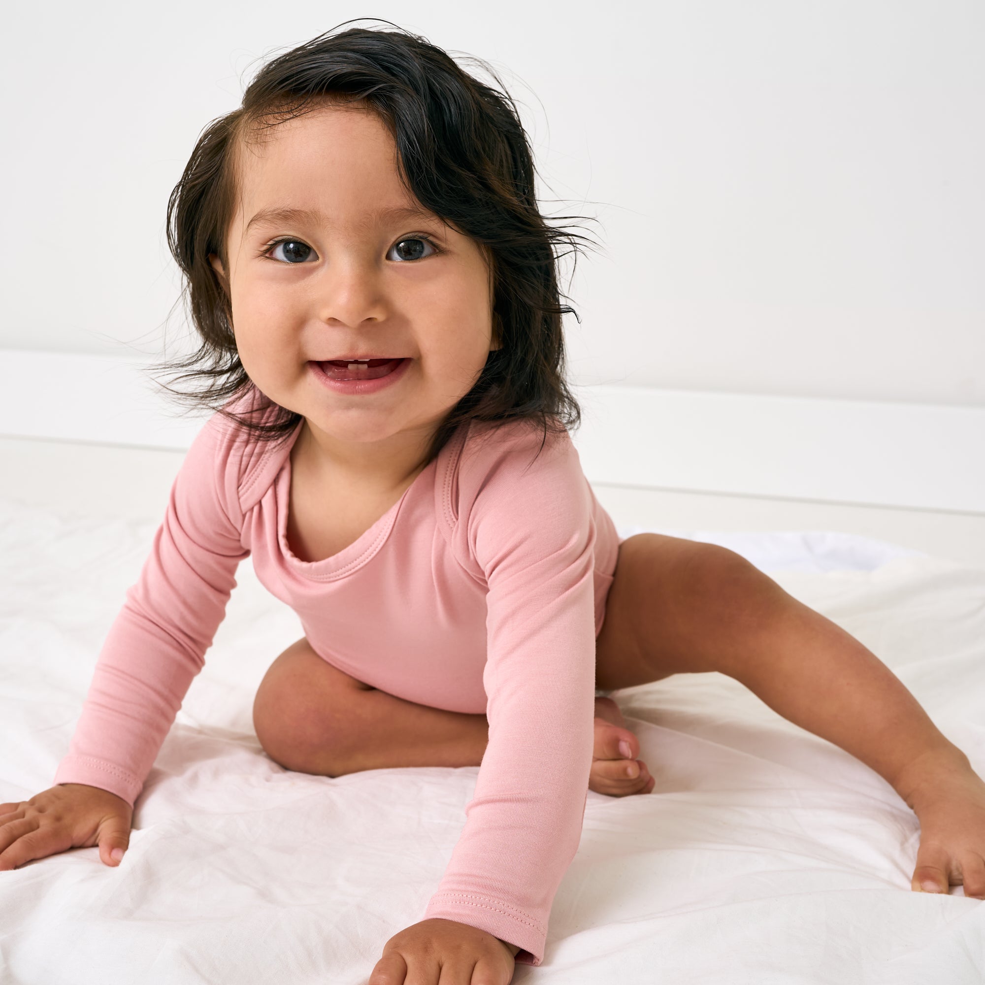 Crawling child wearing the Mauve Blush Long Sleeve Bodysuit