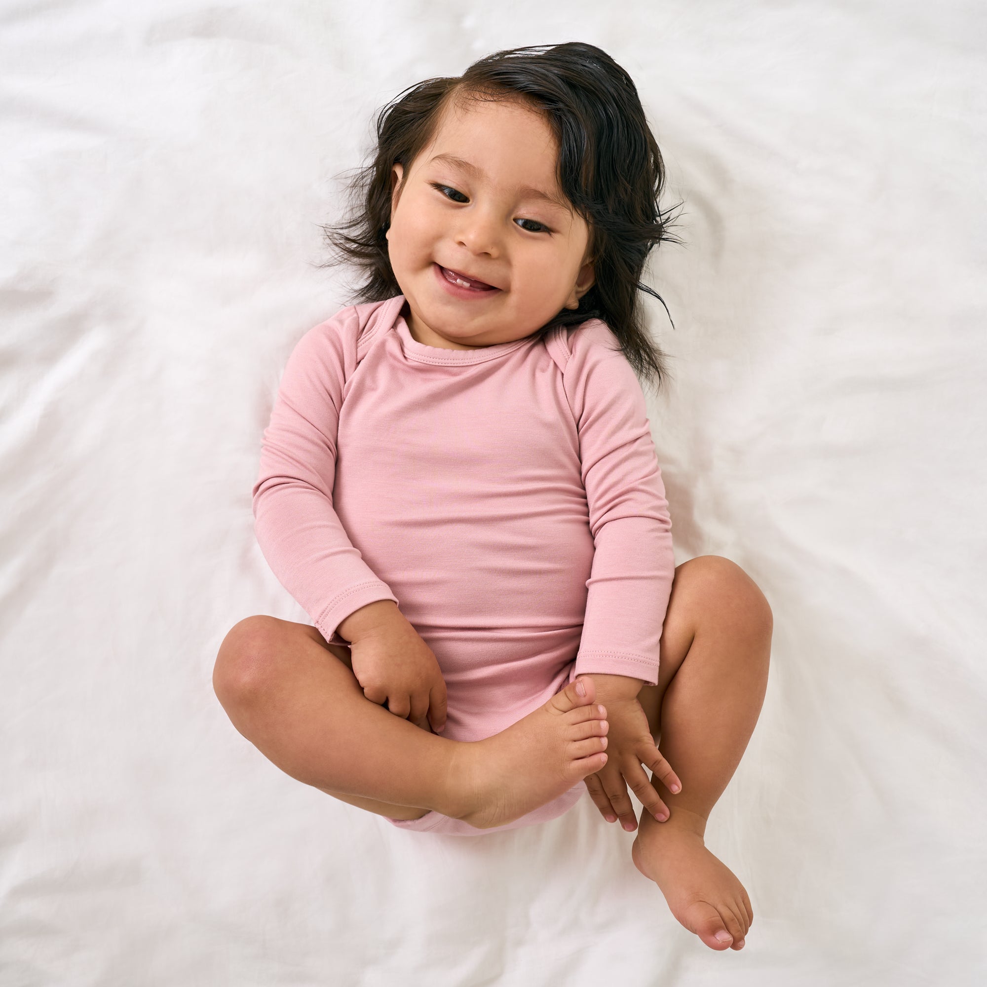 Aerial view of child wearing the Mauve Blush Long Sleeve Bodysuit