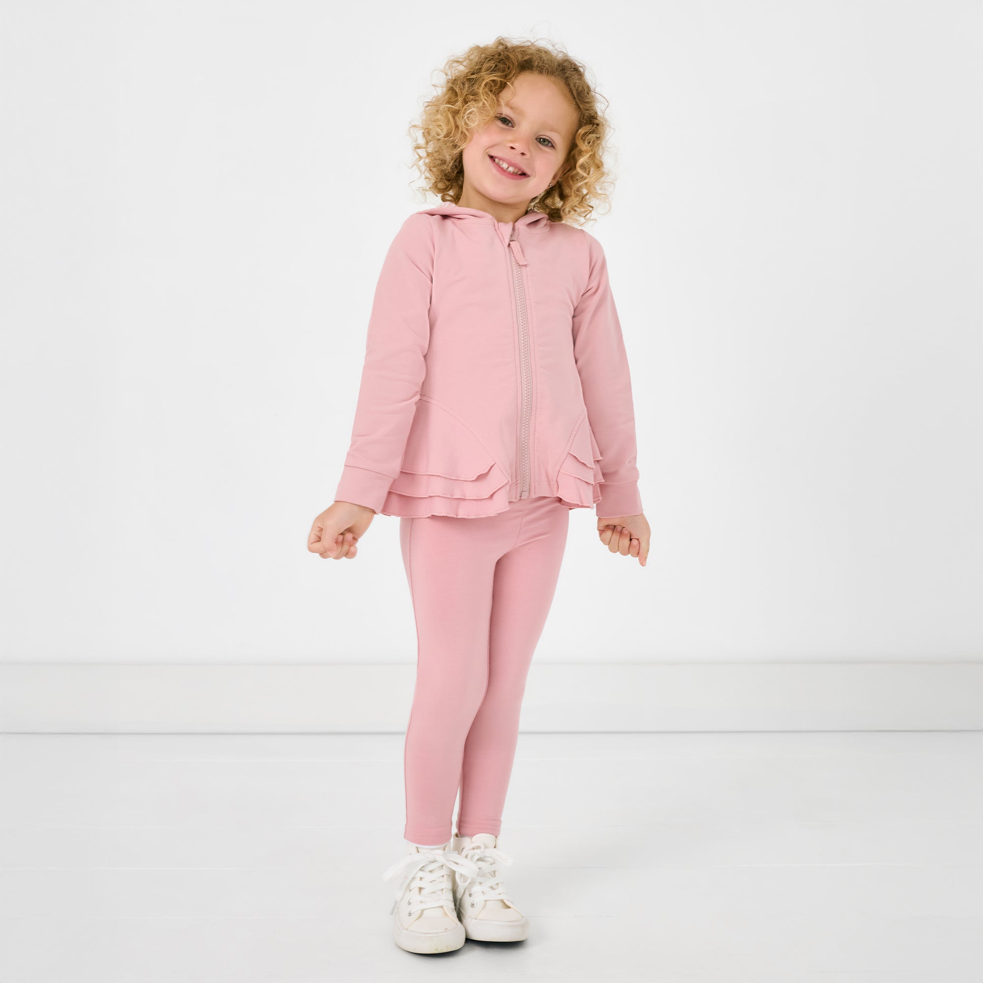 Standing child wearing the Mauve Blush Peplum Hoodie with matching leggings