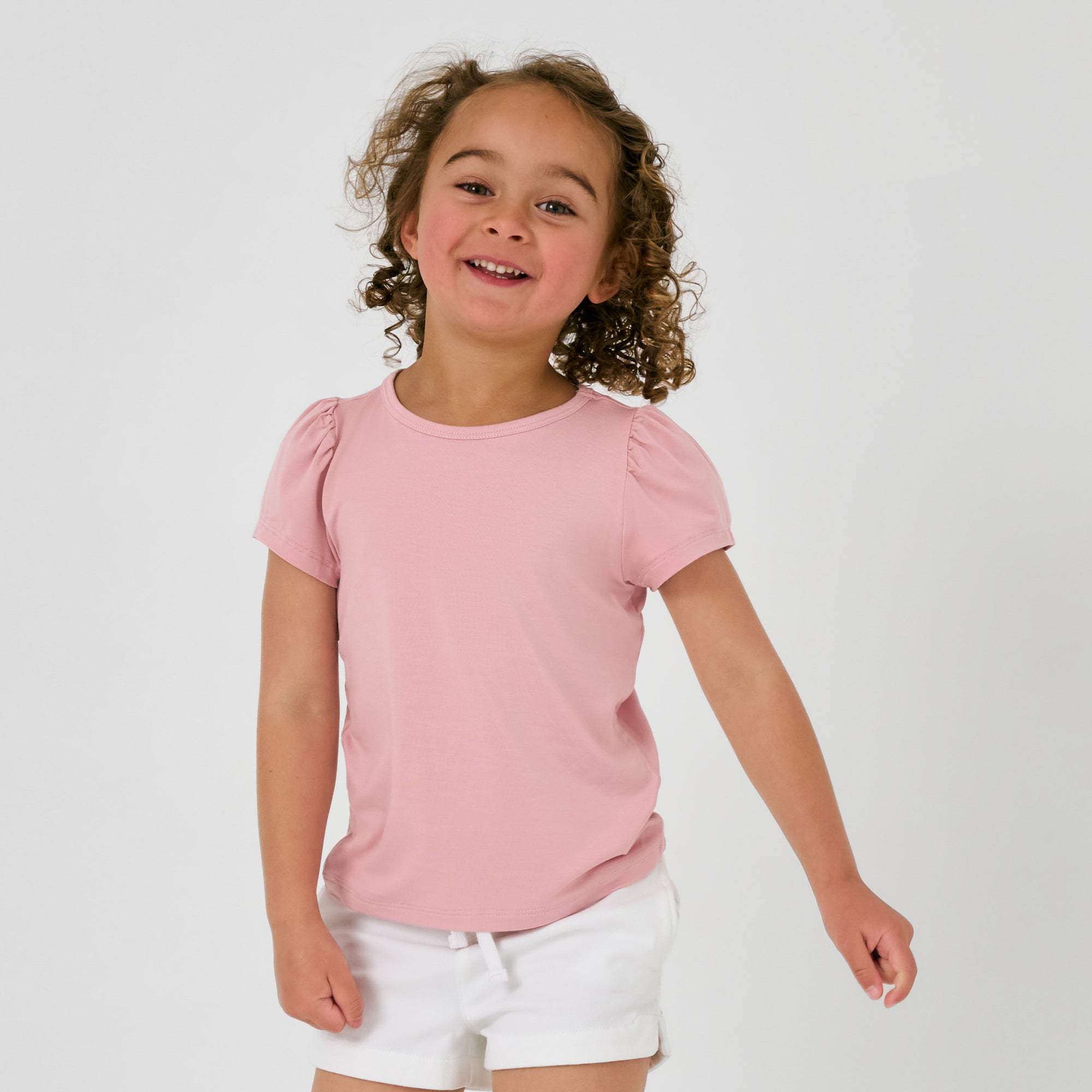 Girl wearing the Mauve Blush Puff Sleeve Tee with white shorts