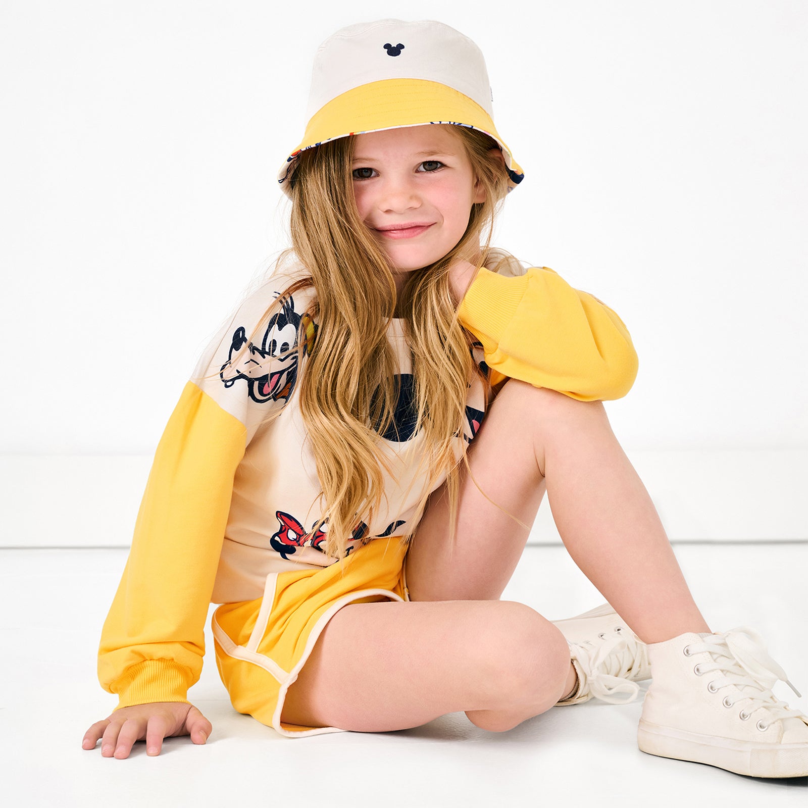 Girl wearing the Disney Mickey's Clubhouse Reversible Bucket Hat with the matching Mickey's Clubhouse outfit