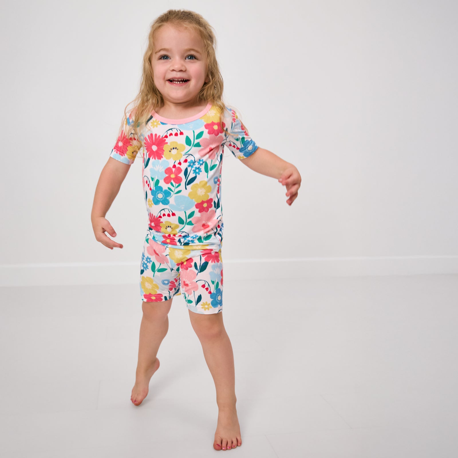 Walking child wearing the Midsummer Meadow Two-Piece Short Sleeve & Shorts Pajama Set