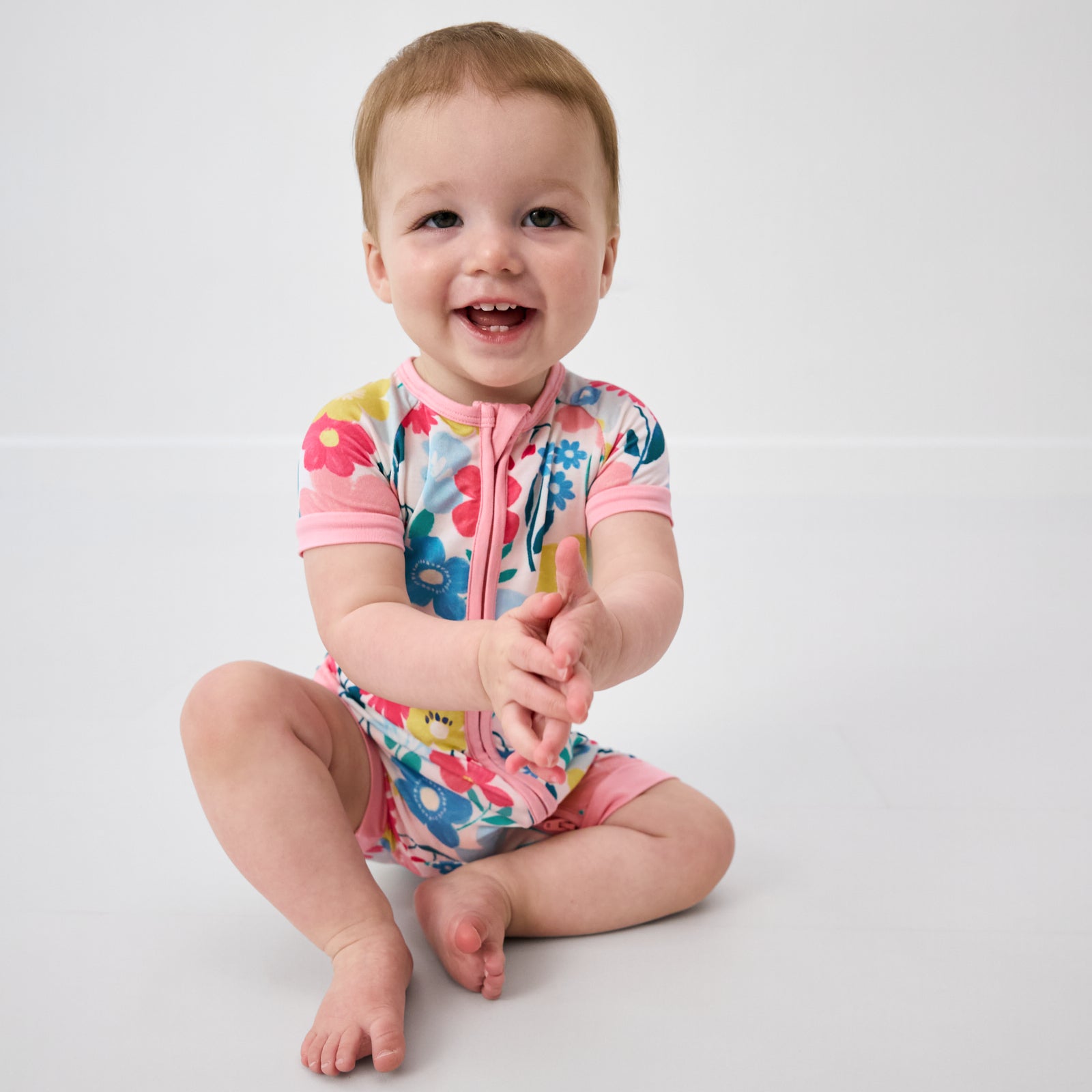 Sitting baby wearing the Midsummer Meadow Shorty Zippy