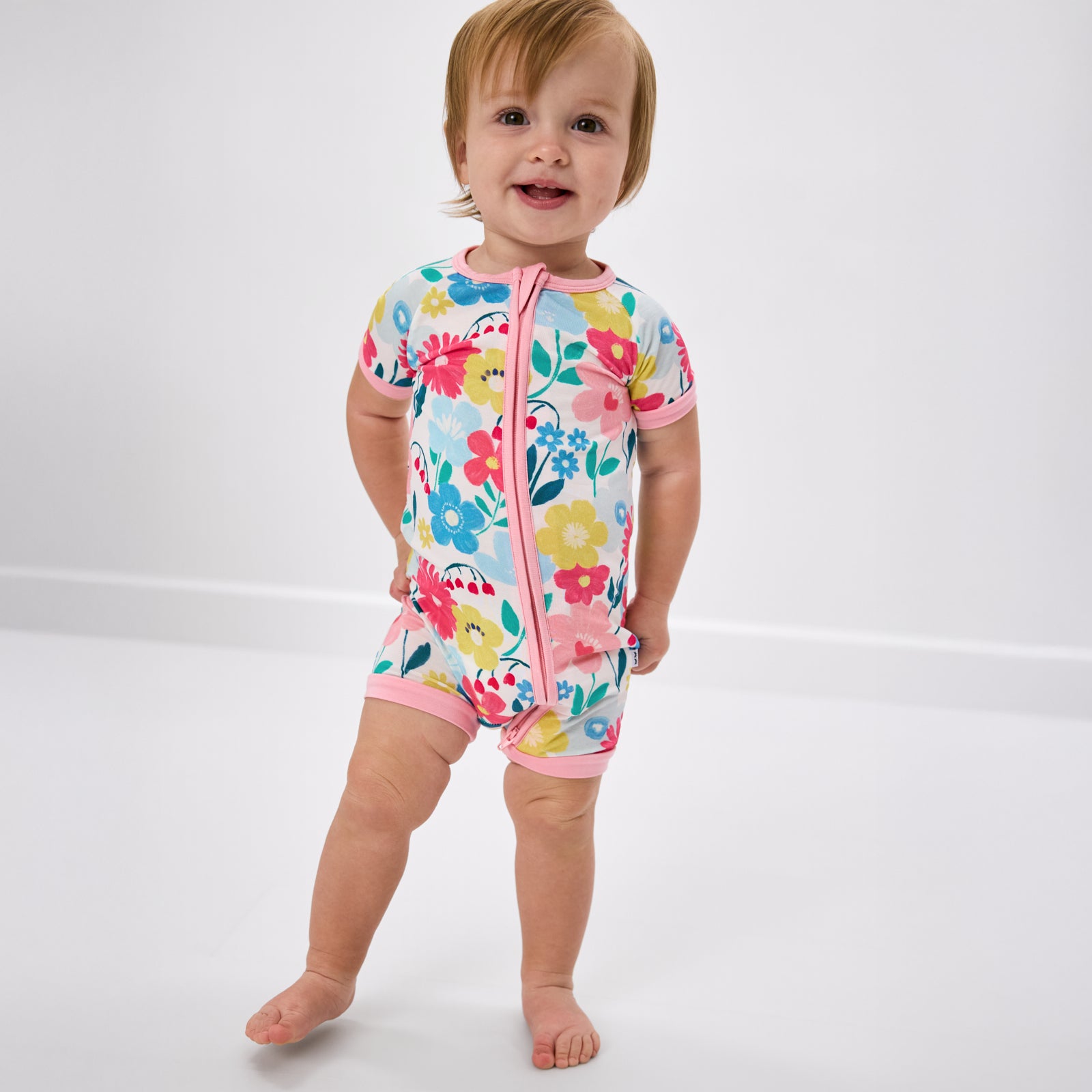 Baby wearing the Midsummer Meadow Floral Shorty Zippy