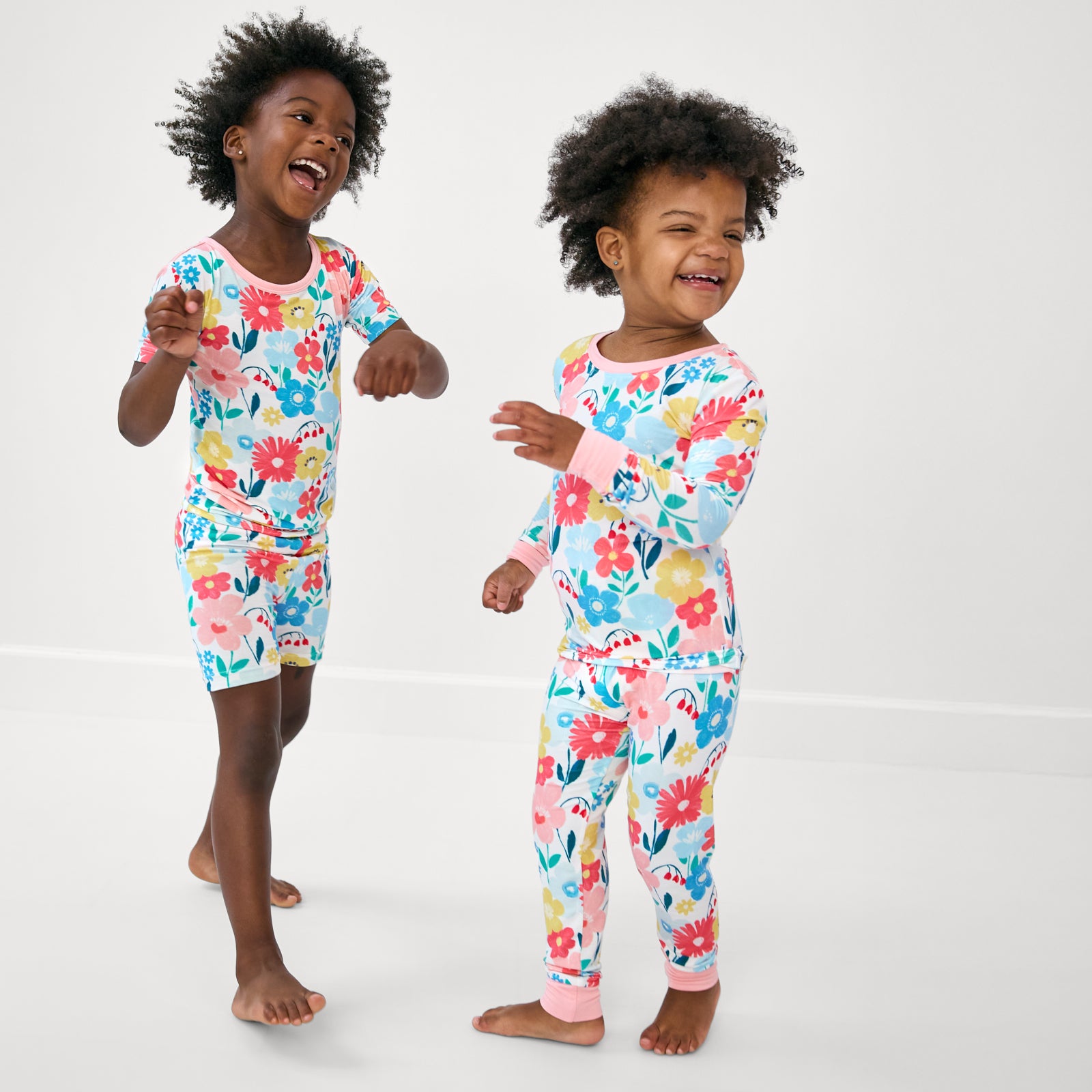 Two siblings wearing matching two-piece bamboo pj sets