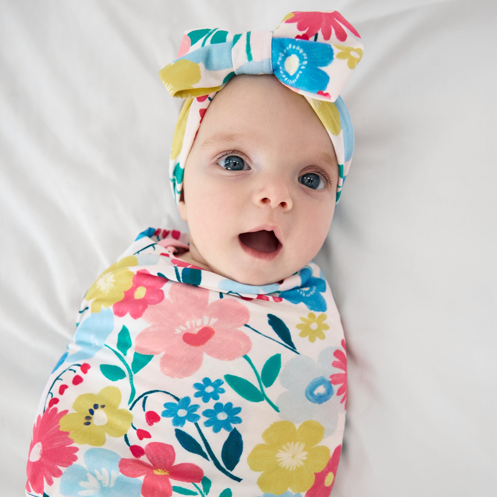 Close up of child wearing the Midsummer Meadow Swaddle & Luxe Bow Headband Set