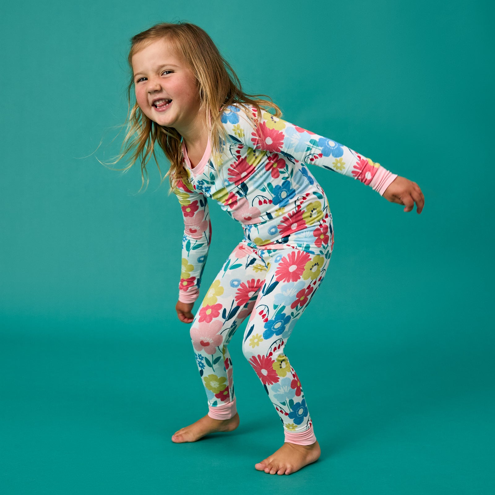 Girl wearing floral pajamas on a teal background