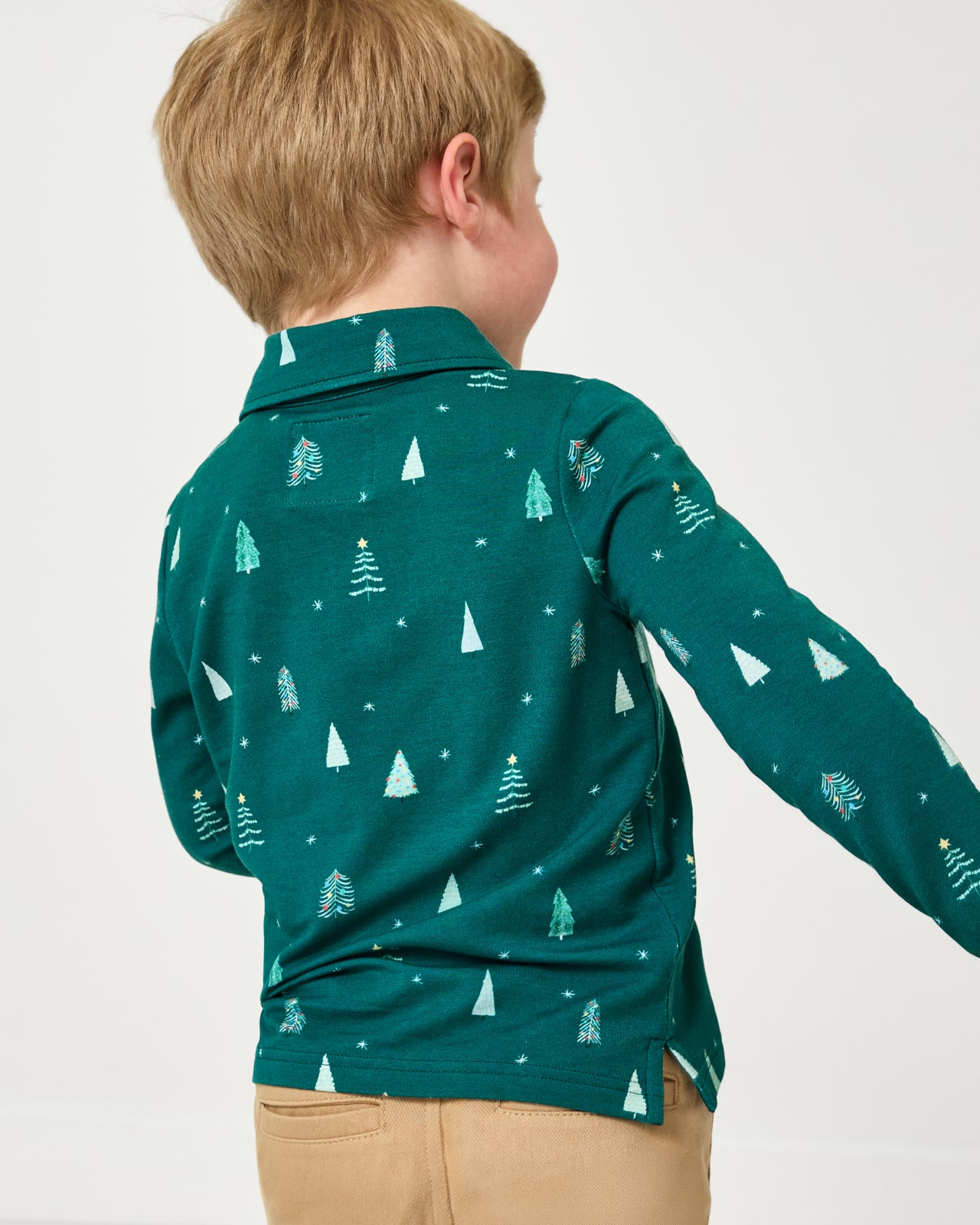 Back view of boy wearing the Twinkling Trees Polo Shirt