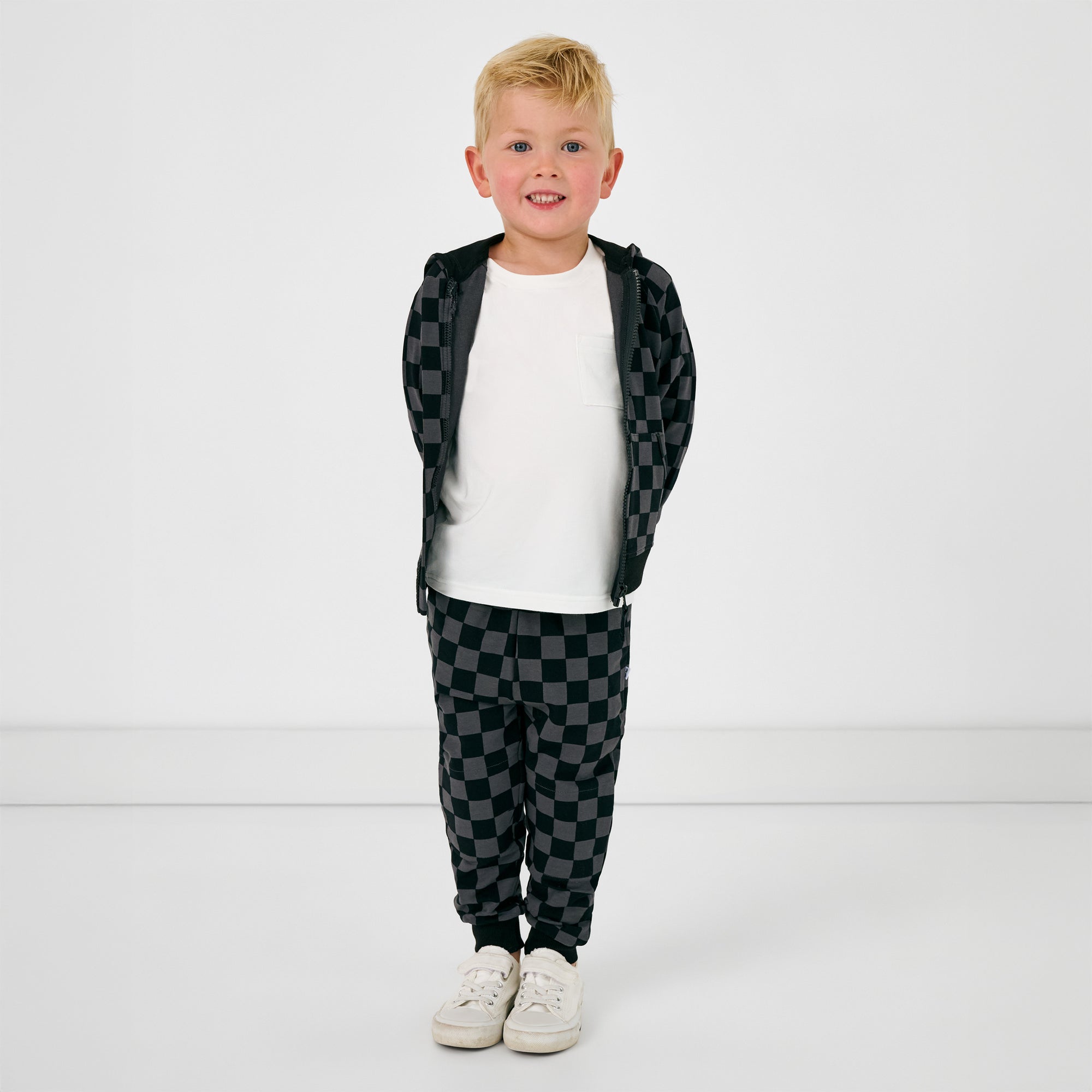 Standing child wearing the Monochrome Checks Jogger with the matching zip up hoodie