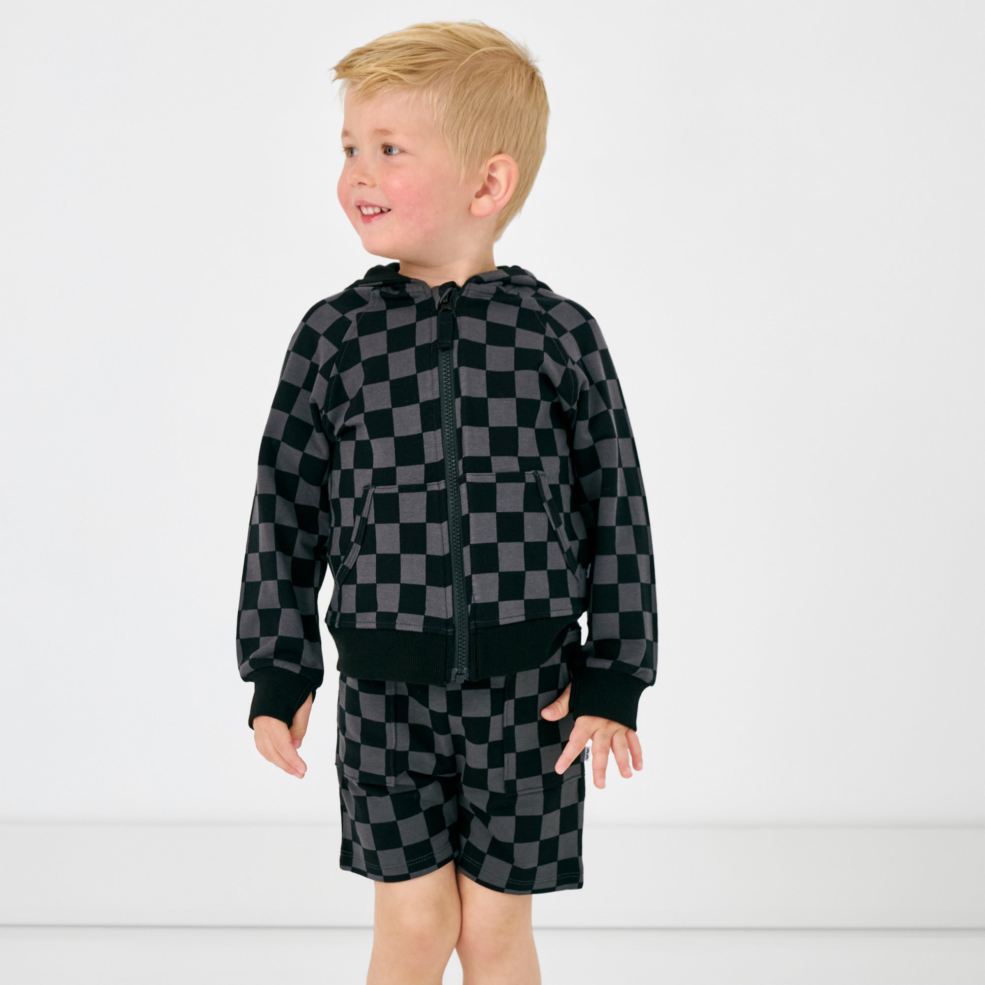 Standing boy wearing the Monochrome Checks Shorts and matching shorts