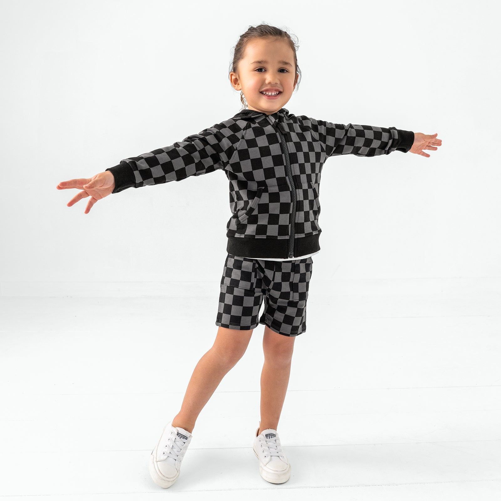 Standing child wearing the Monochrome Checks Shorts with a matching zip up hoodie