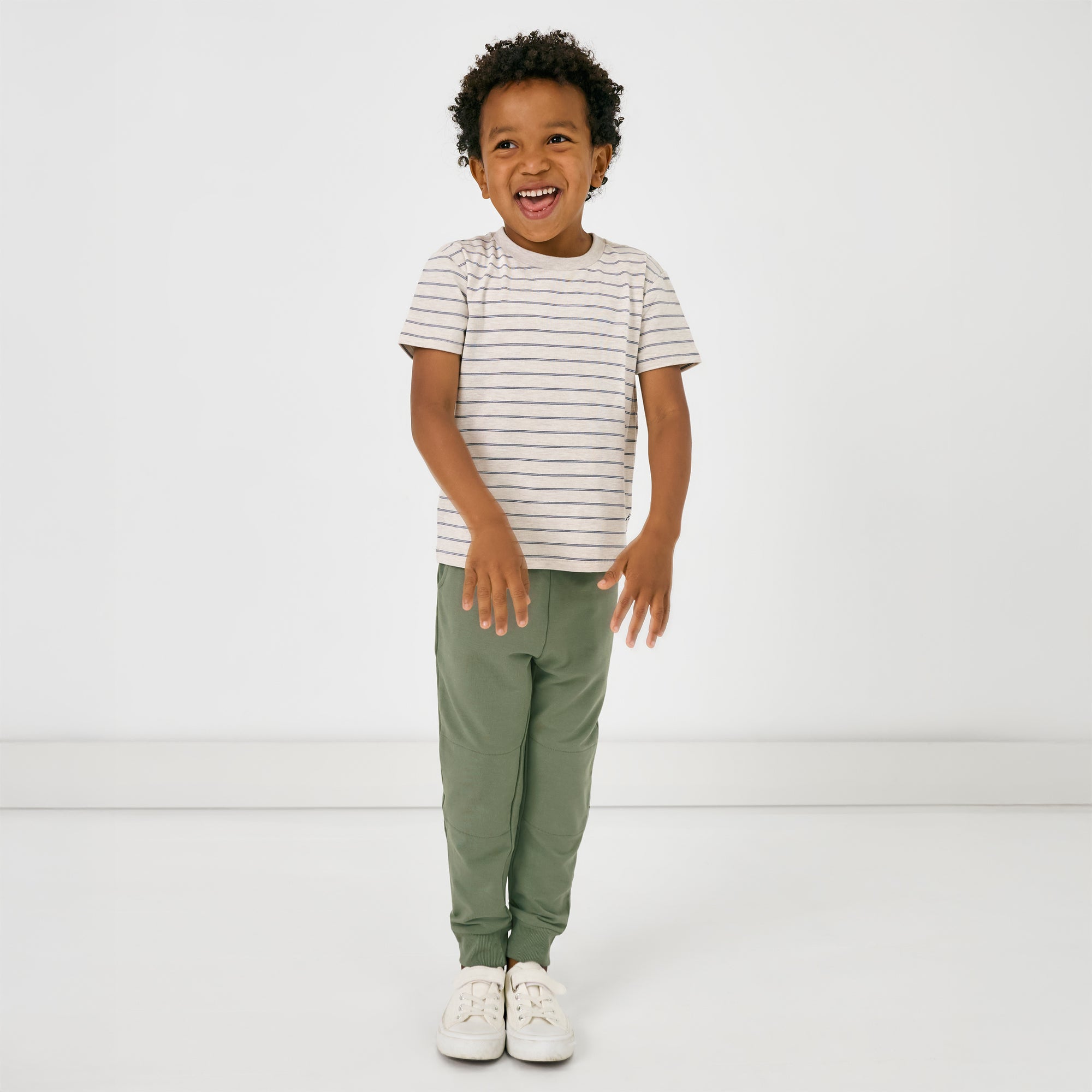 Standing child wearing the Moss Jogger with the stone stripes tee
