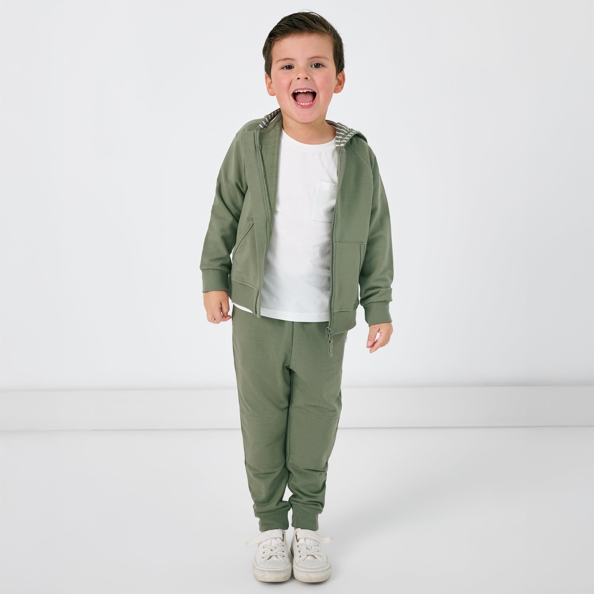 Standing child wearing the Moss Jogger and matching Zip hoodie