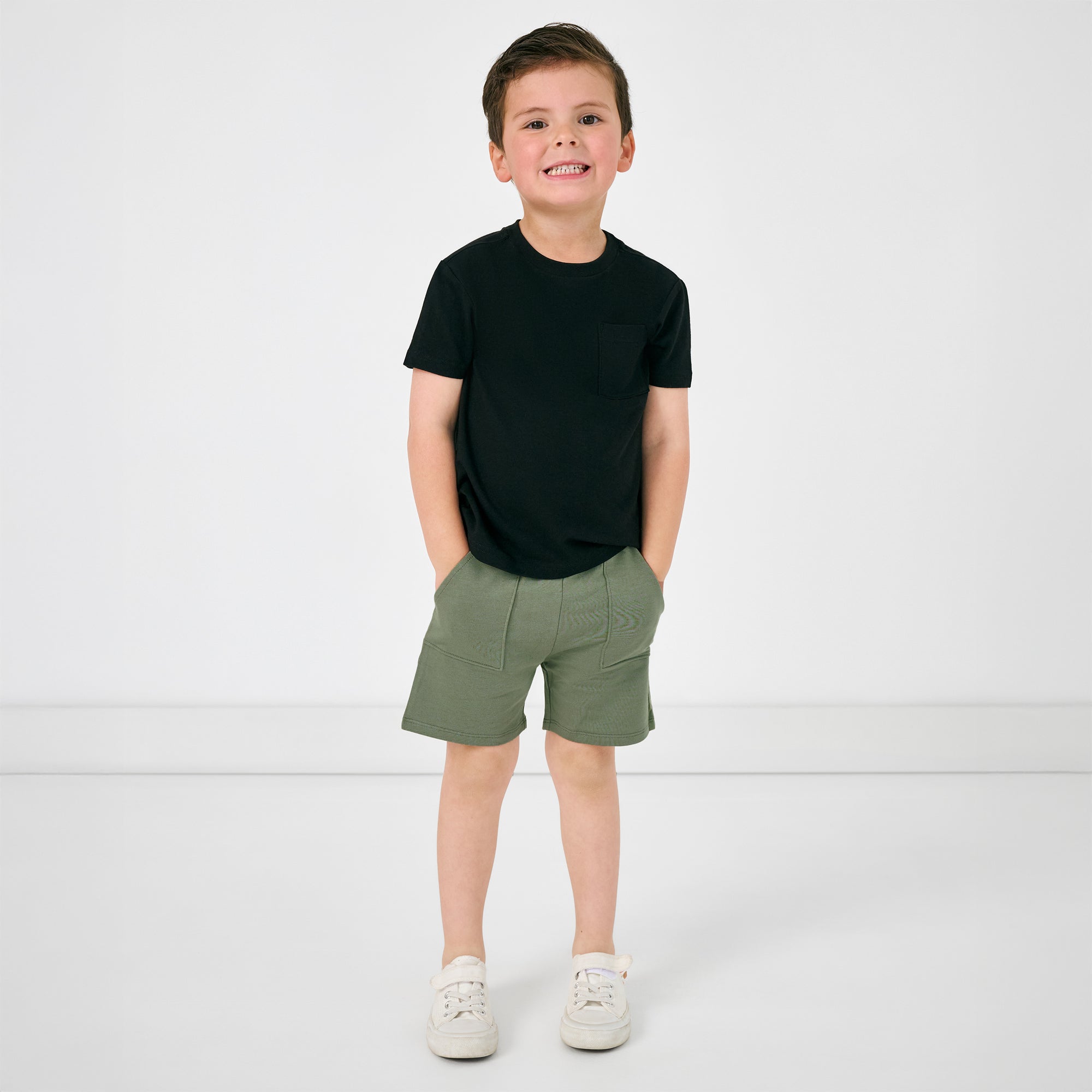 Standing child wearing the Moss Shorts and black pocket tee