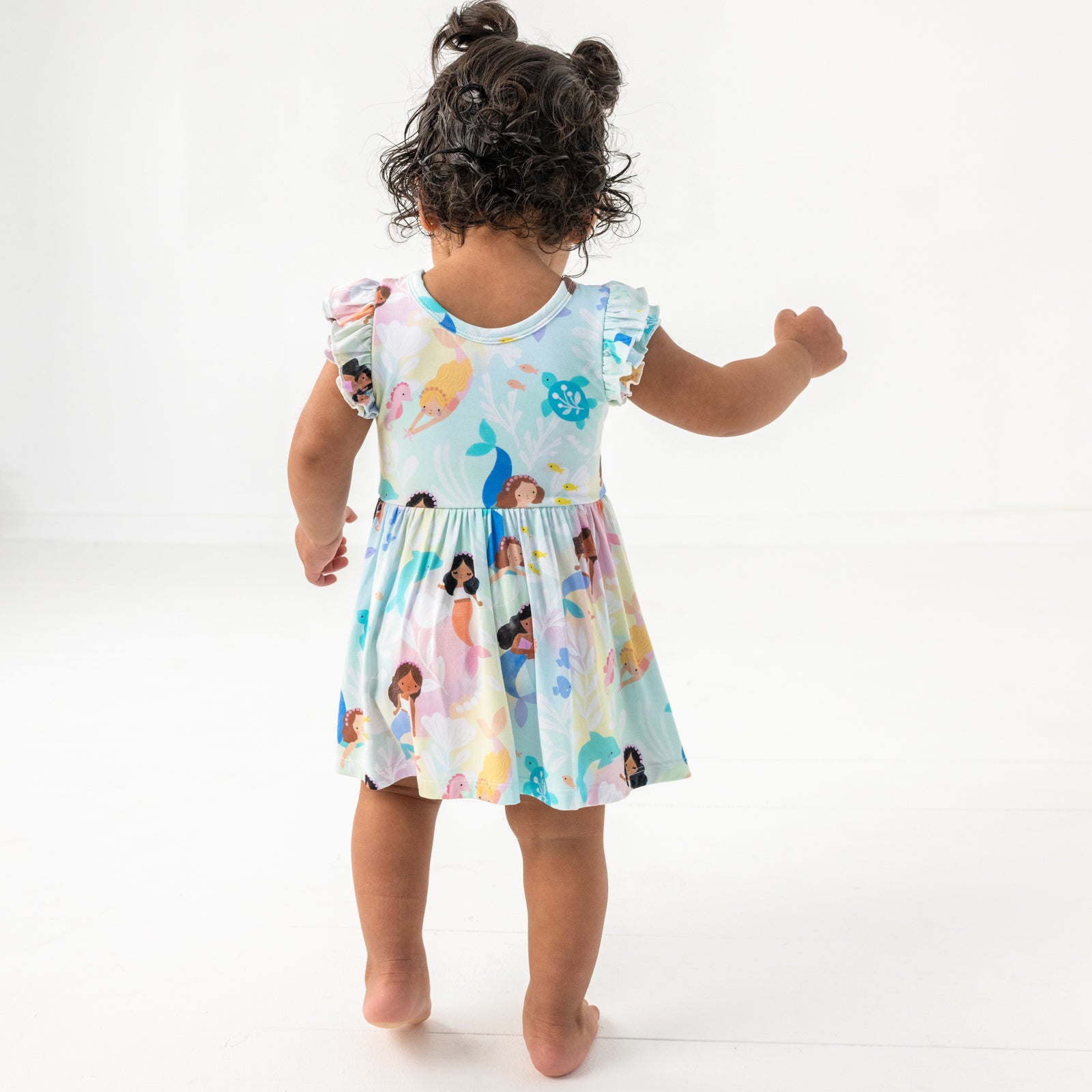 Back view of child wearing the Mystic Mermaids Flutter Twirl Dress with Bodysuit