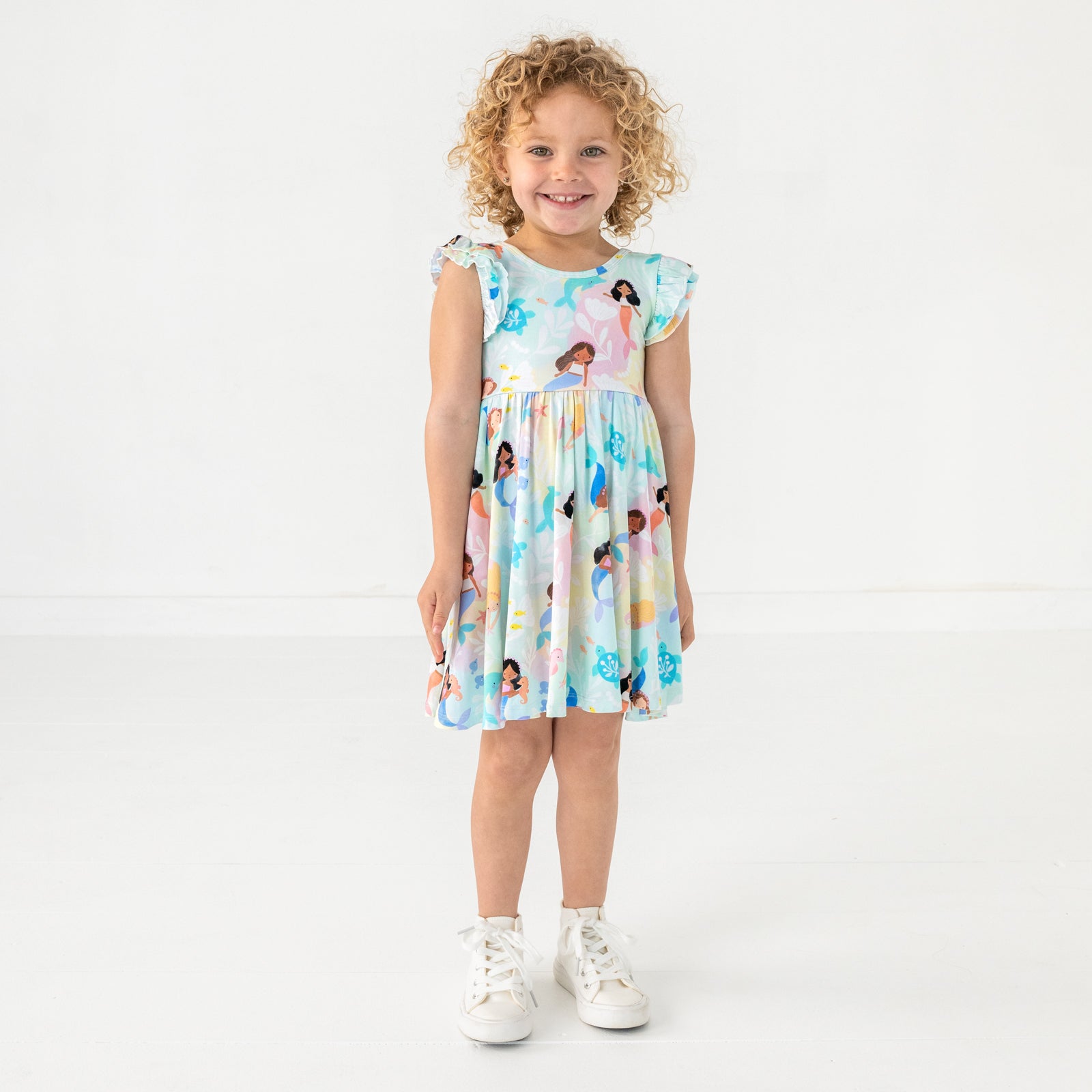 Standing child wearing the Mystic Mermaids Flutter Twirl Dress