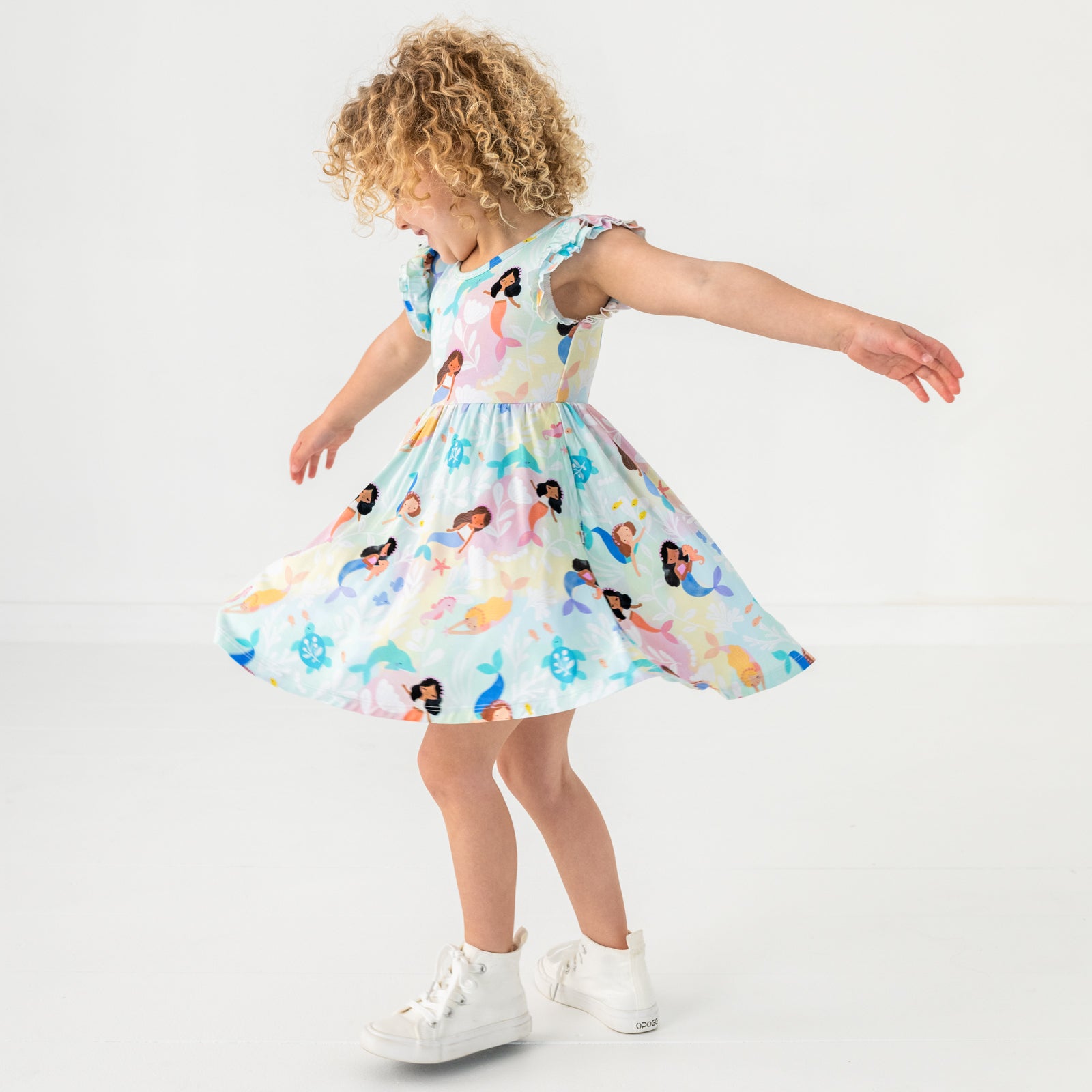 Twirling child wearing the Mystic Mermaids Flutter Twirl Dress