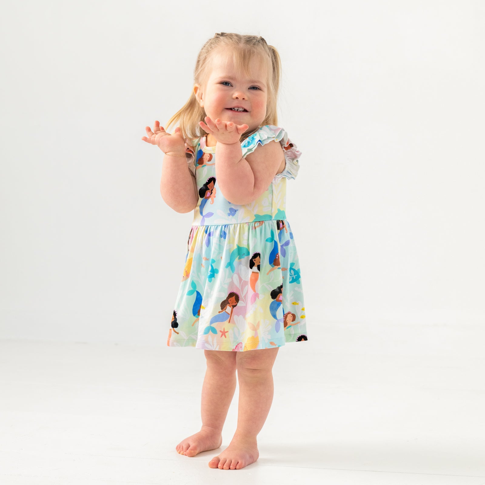 Posing child wearing the Mystic Mermaids Flutter Twirl Dress with Bodysuit