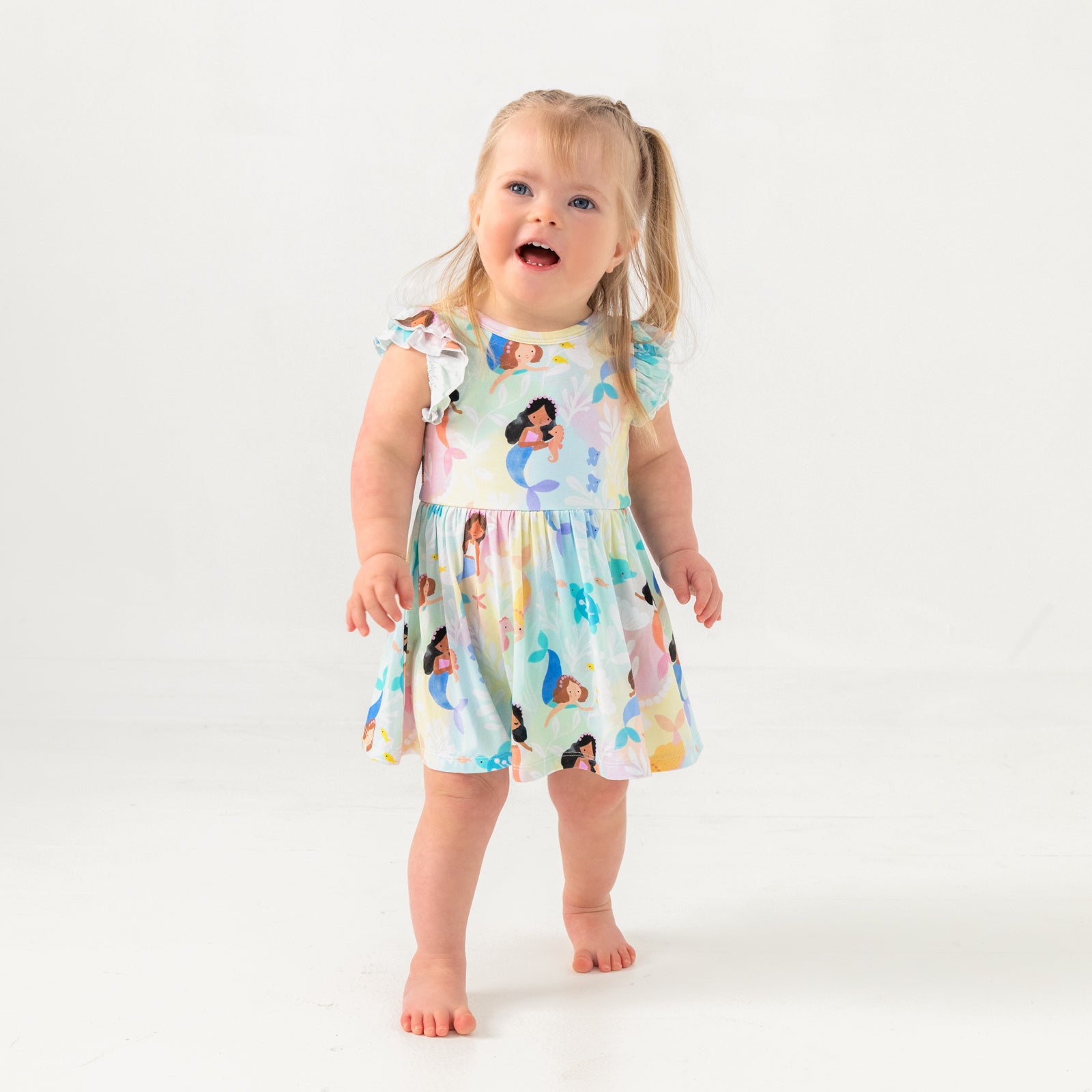 Alternate standing child wearing the Mystic Mermaids Flutter Twirl Dress with Bodysuit