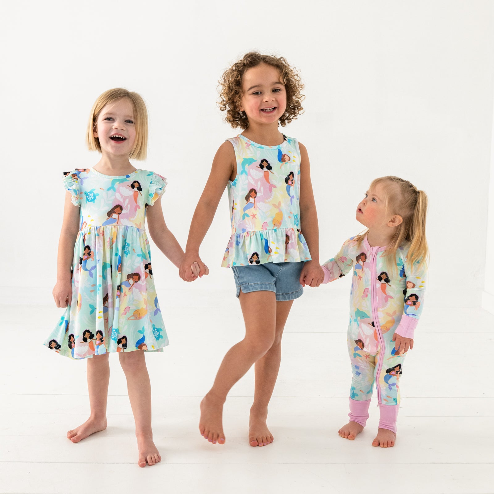 Three children wearing matching Mystic Mermaids sleep and play styles