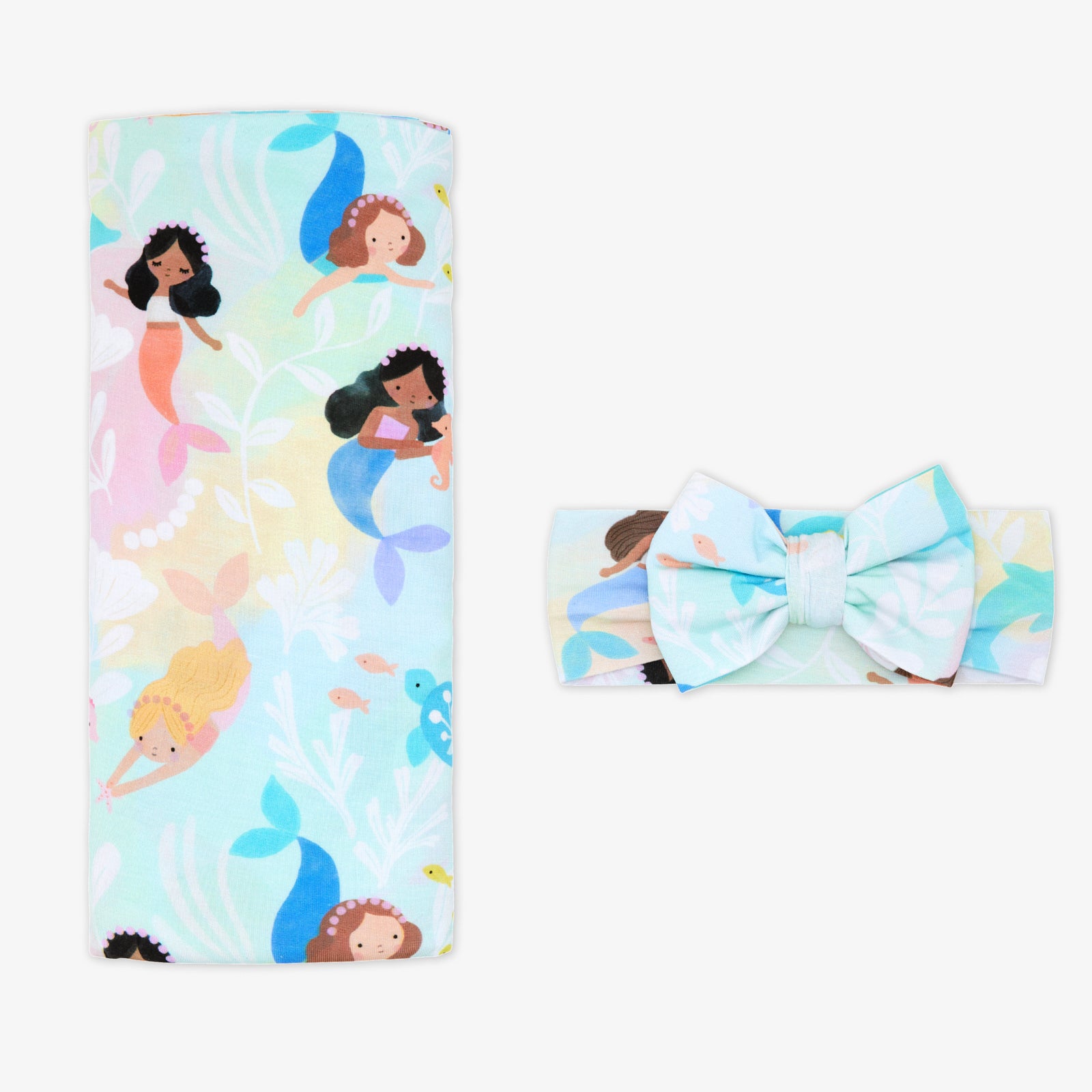 Flat lay of the Mystic Mermaids Swaddle & Luxe Bow Headband Set