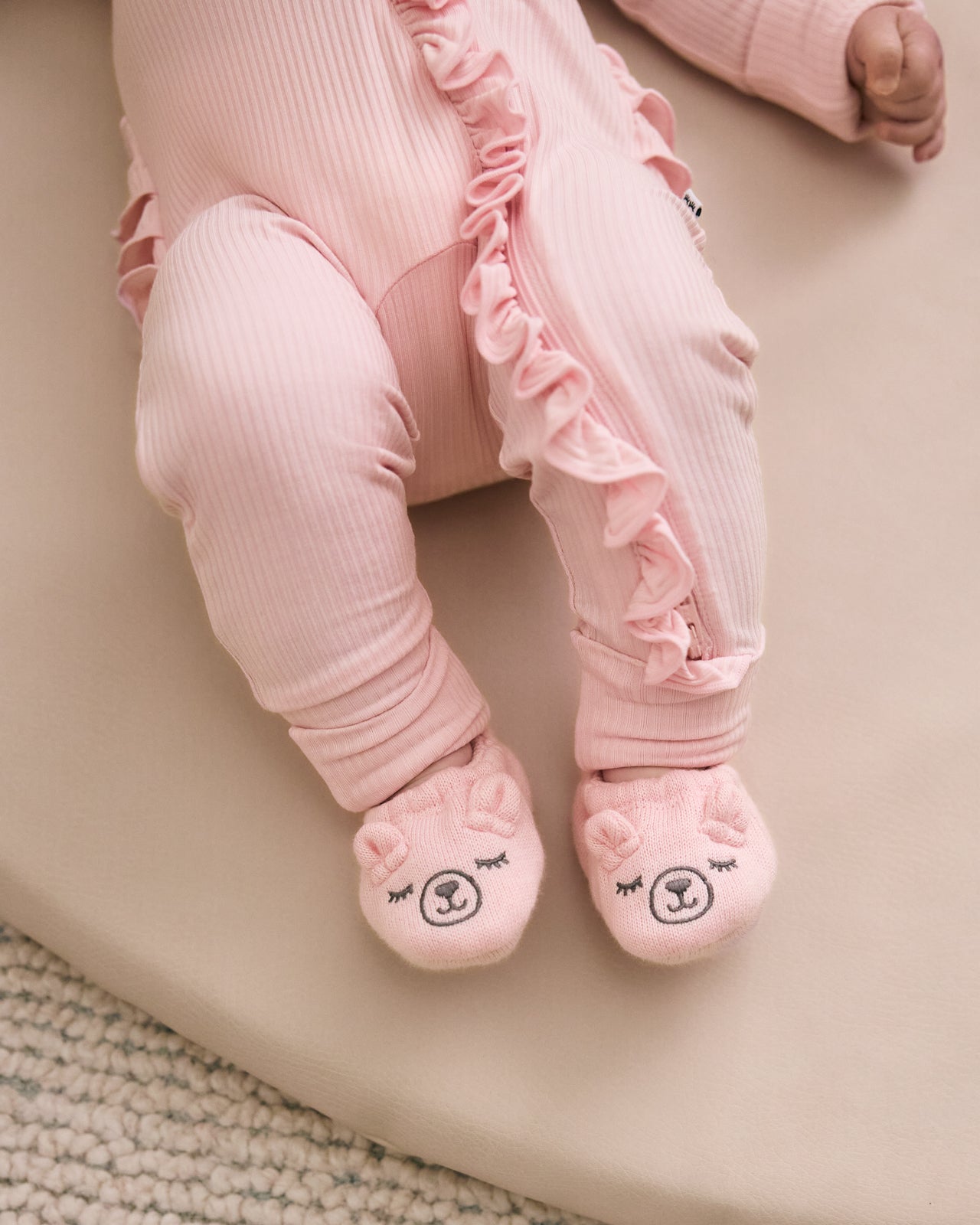 Baby wearing the Prima Pink Bear Booties with a coordinating pink newborn zippy