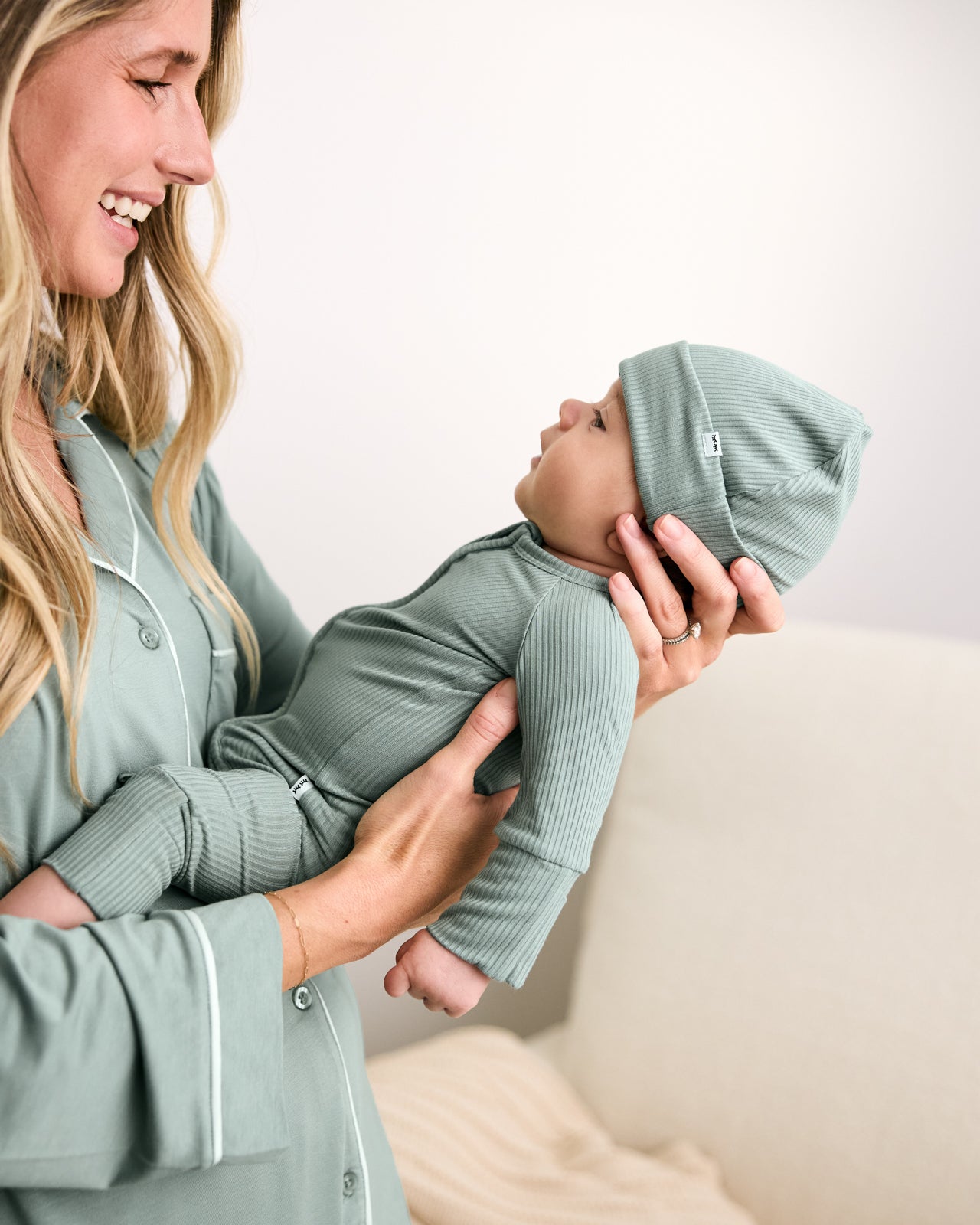 Mother holding baby wearing the Willow Ribbed Zippy
