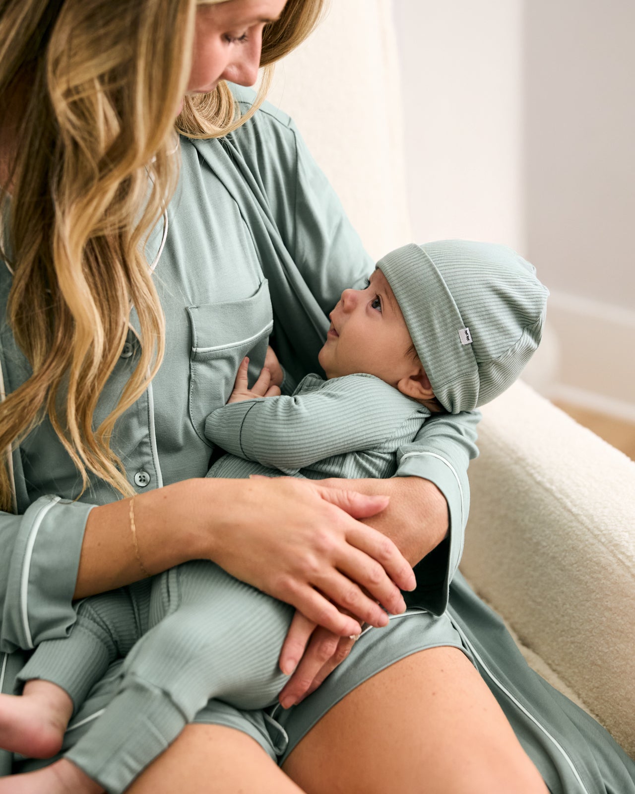 Mother holding baby wearing the Willow Ribbed Infant Beanie