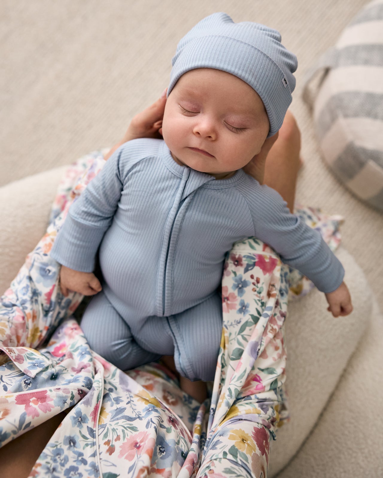 Newborn wearing the Light Fog Ribbed Infant Beanie being held