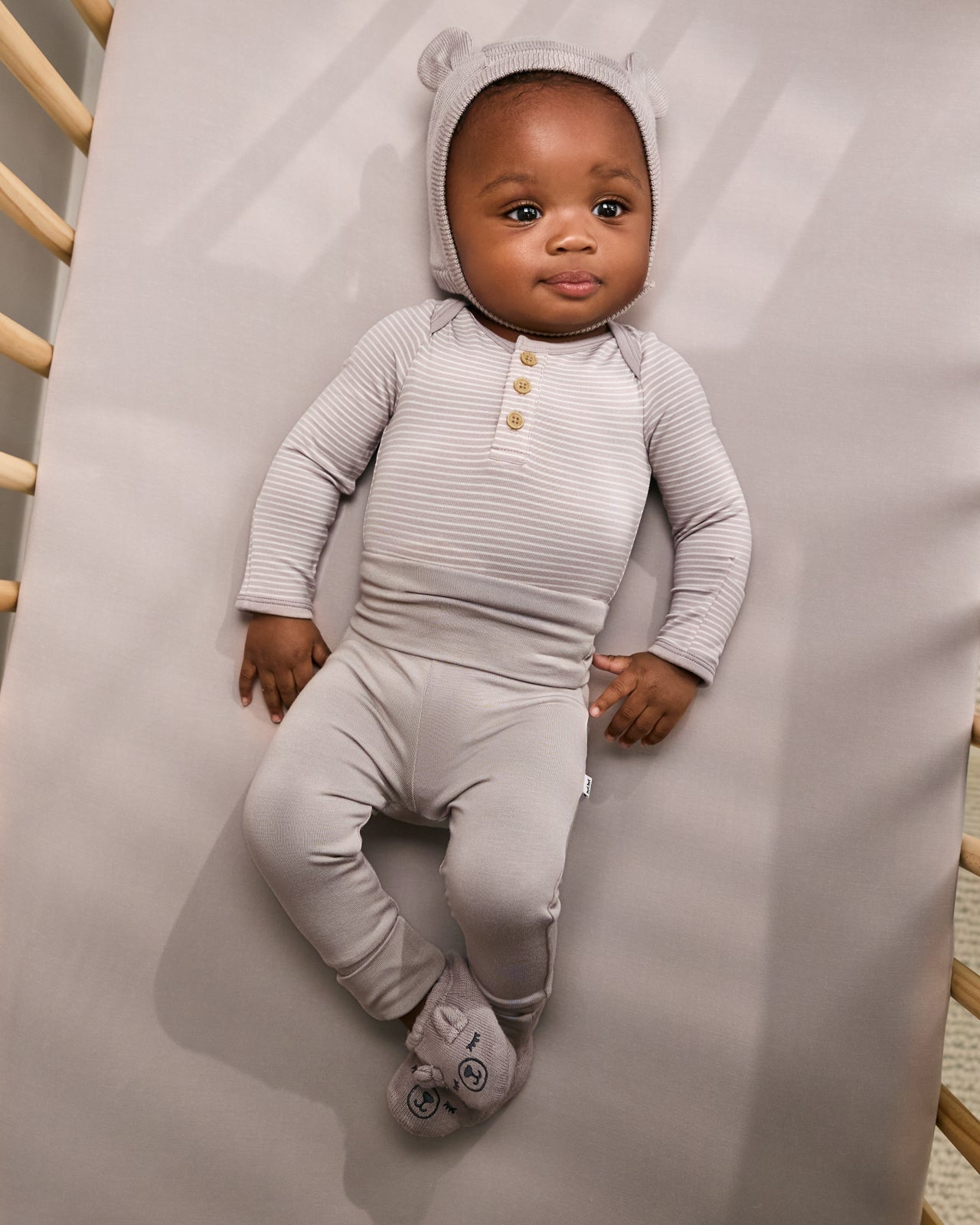 Aerial view of baby wearing the Dove Gray Bear Bonnet with matching bear booties