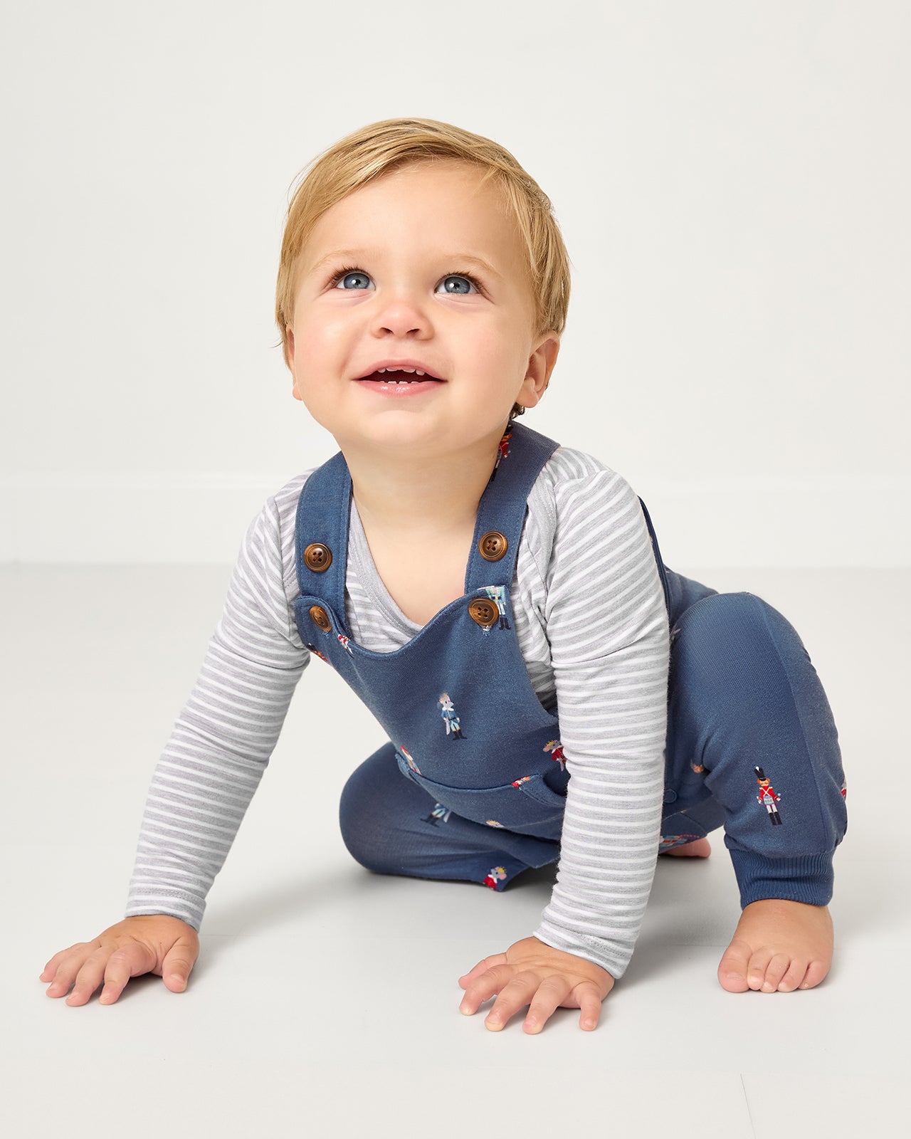 Crawling baby wearing the Nutcracker March Overall Romper