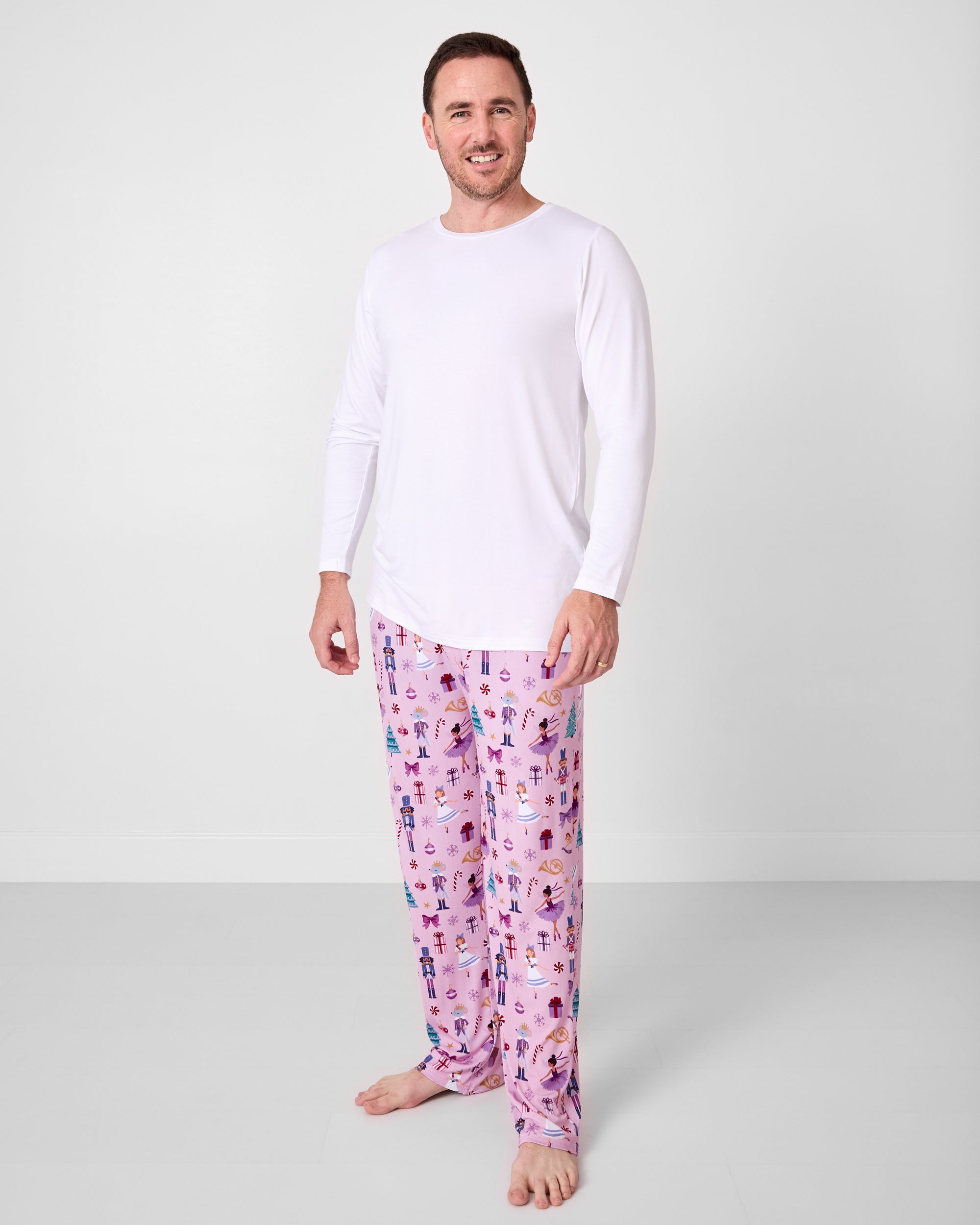 Man wearing the Nutcracker Ballet Men's Pajama Pants with a bright white pajama top
