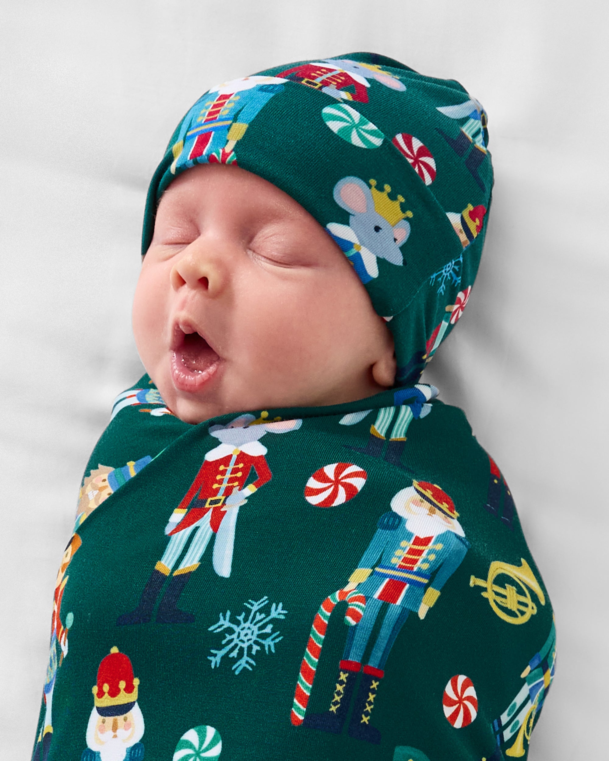 Close up of baby wearing the Nutcracker March Swaddle & Hat Set
