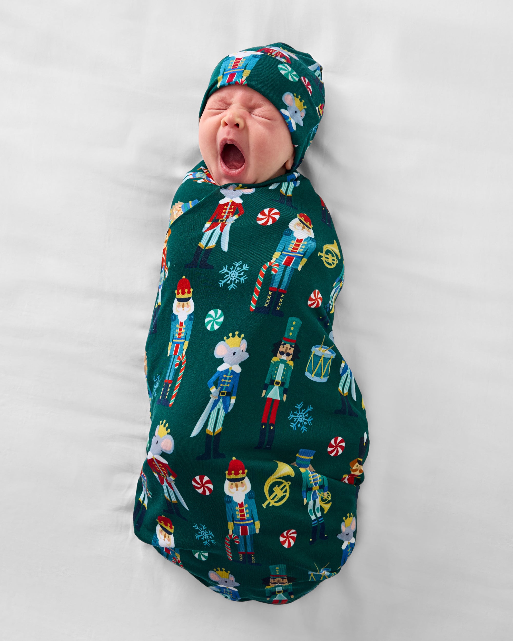 Baby wearing the Nutcracker March Swaddle & Hat Set