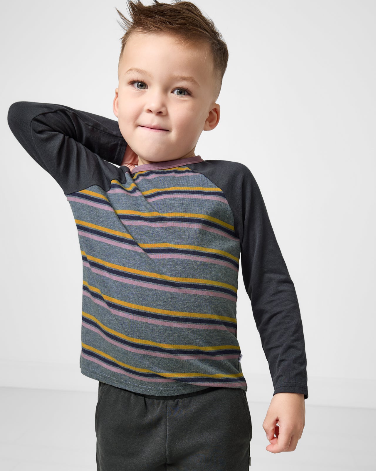 Close up of boy wearing the Ollie Stripe Raglan Tee