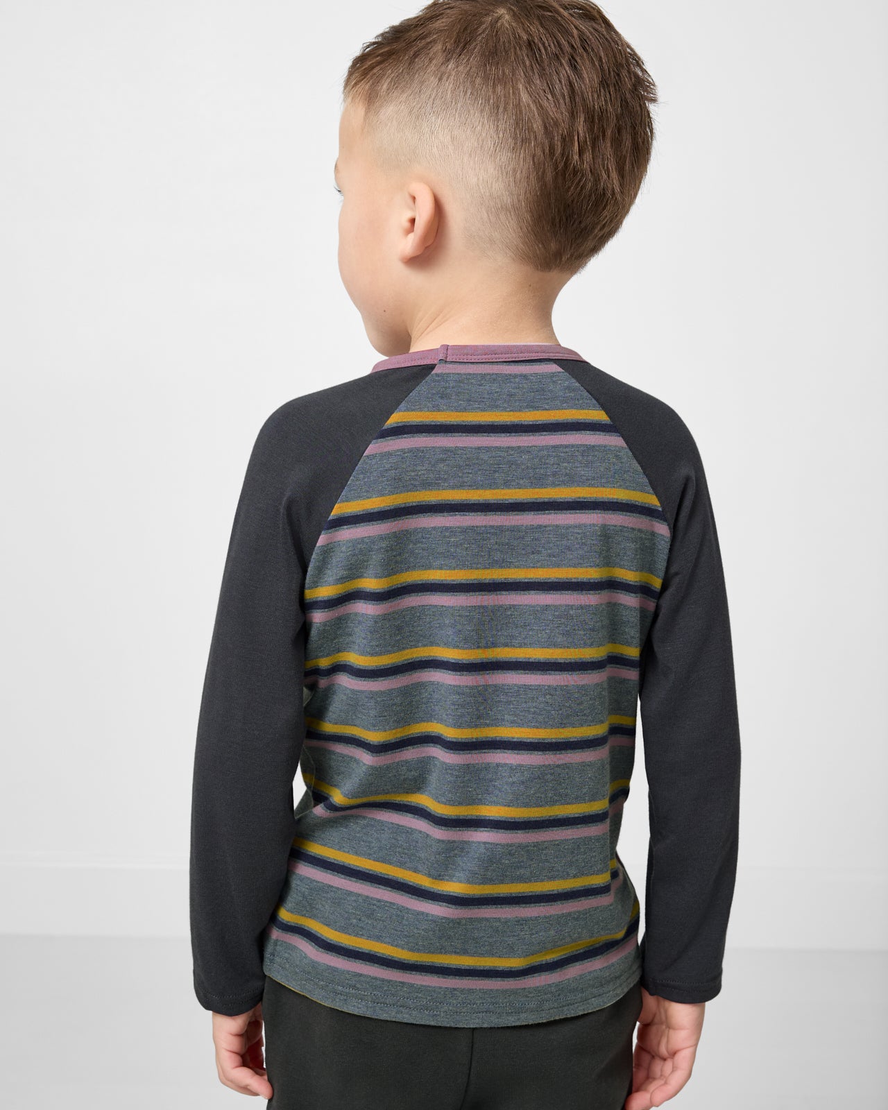 Back view of child wearing the Ollie Stripe Raglan Tee