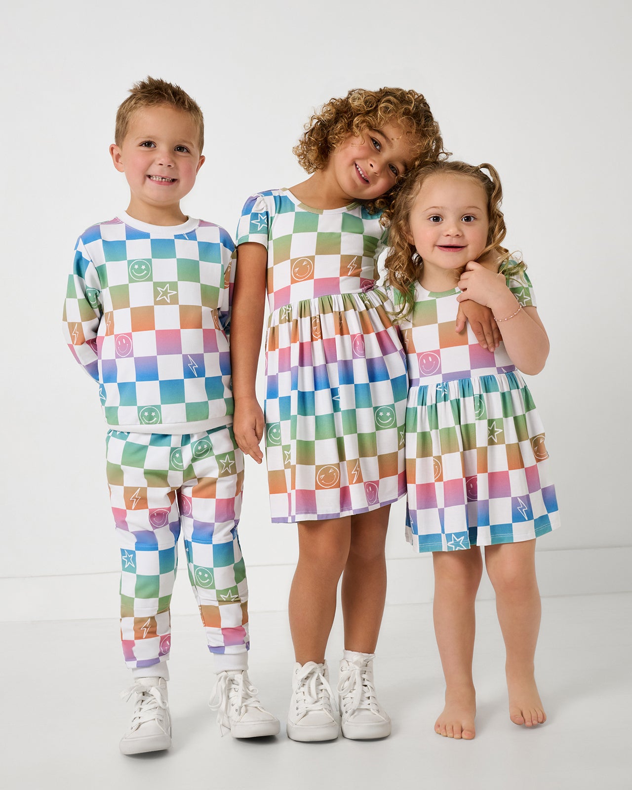 Group of three children wearing matching Ombre Cheery Checks play styles