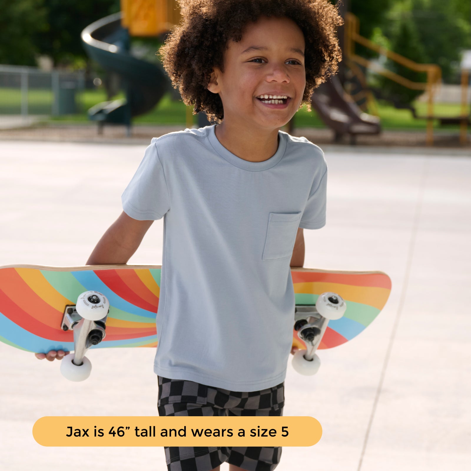Boy holding skateboard and wearing the Fog Relaxed Short Sleeve Relaxed Pocket Tee and Monochrome Checker Shorts