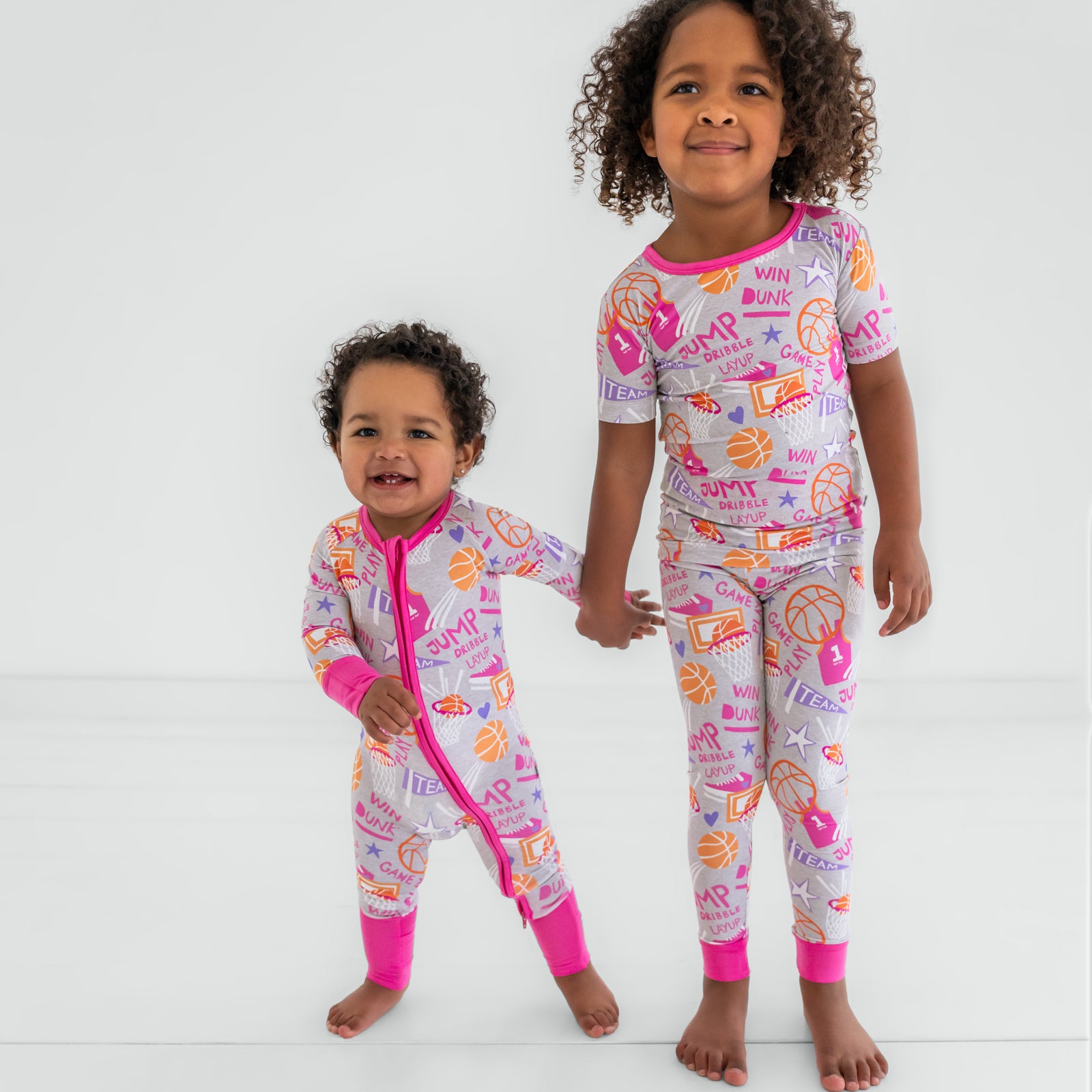 Two children wearing matching Pink Slam Dunk kids pajamas