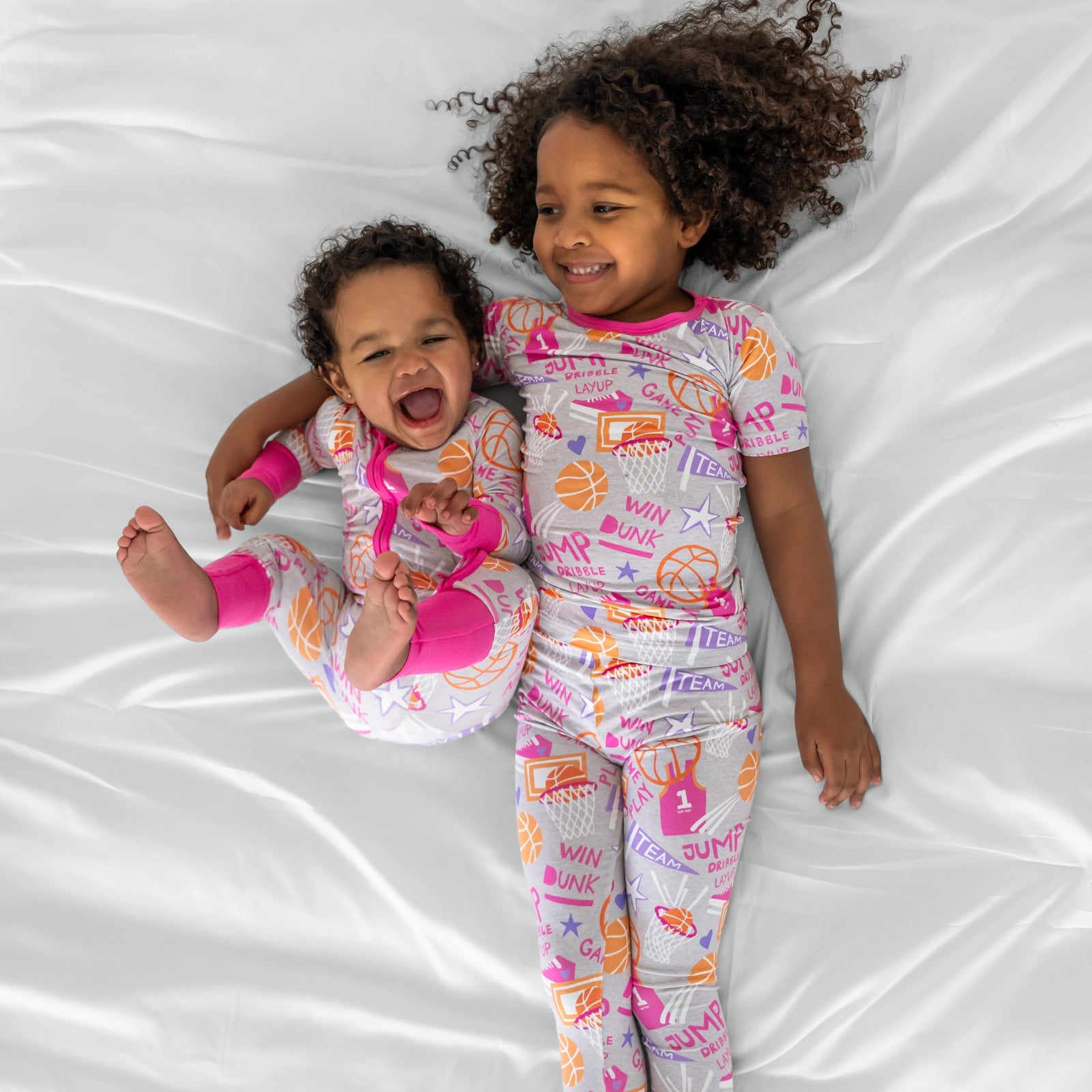 Two children wearing matching Pink Slam Dunk bamboo pajamas