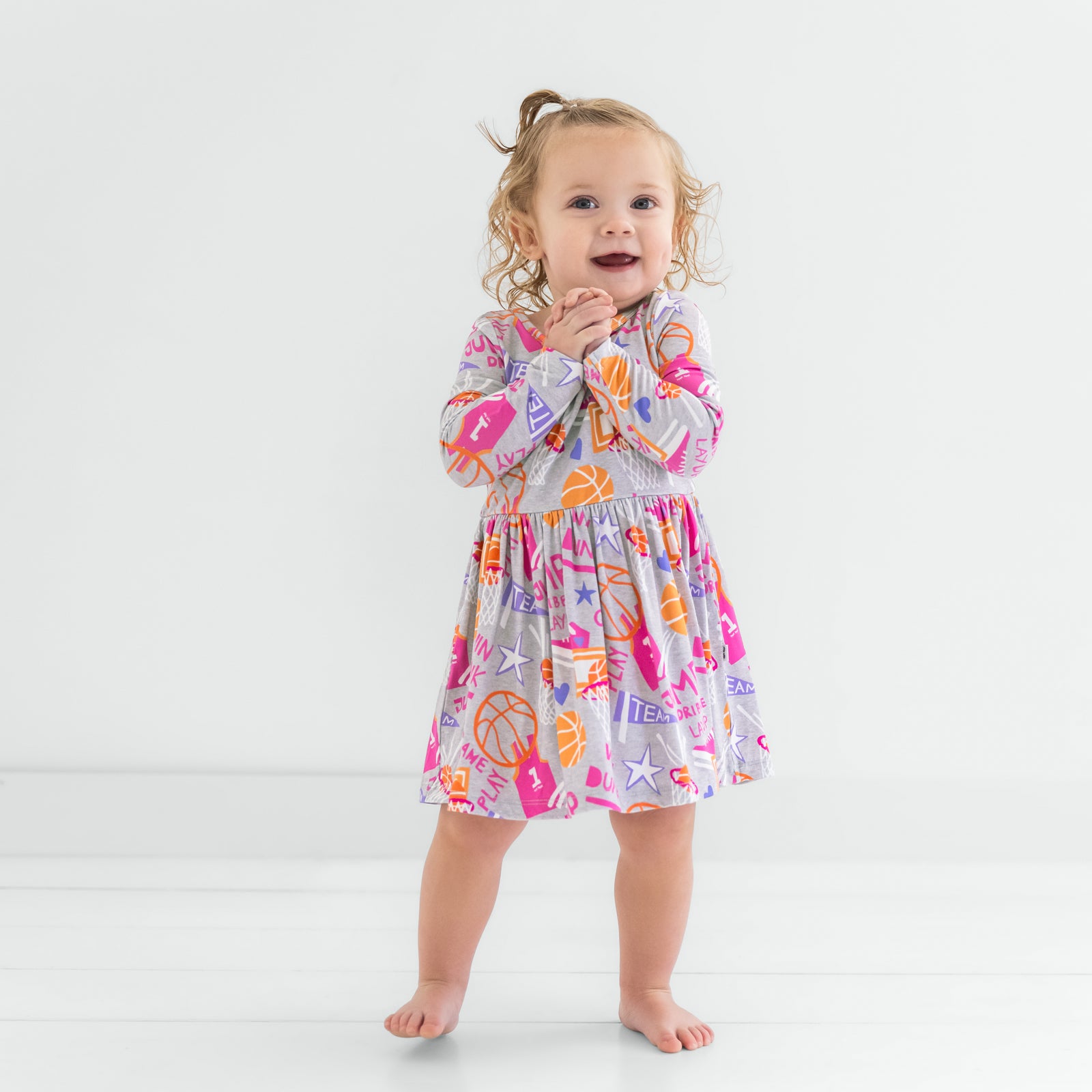 Standing child wearing the Pink Slam Dunk Skater Dress with Bodysuit