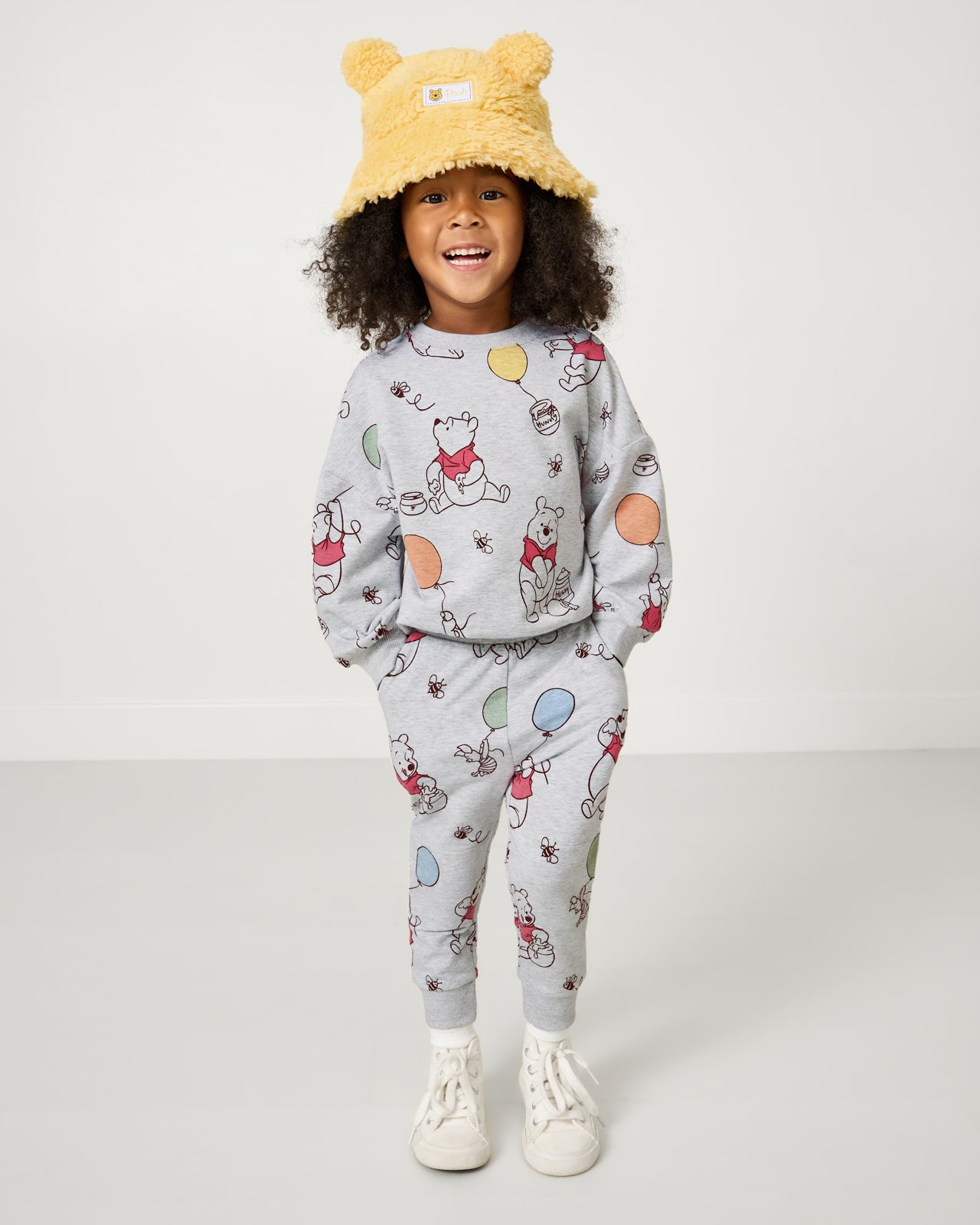 Girl wearing the Disney Winnie the Pooh Sherpa Bucket Hat with a sweat set