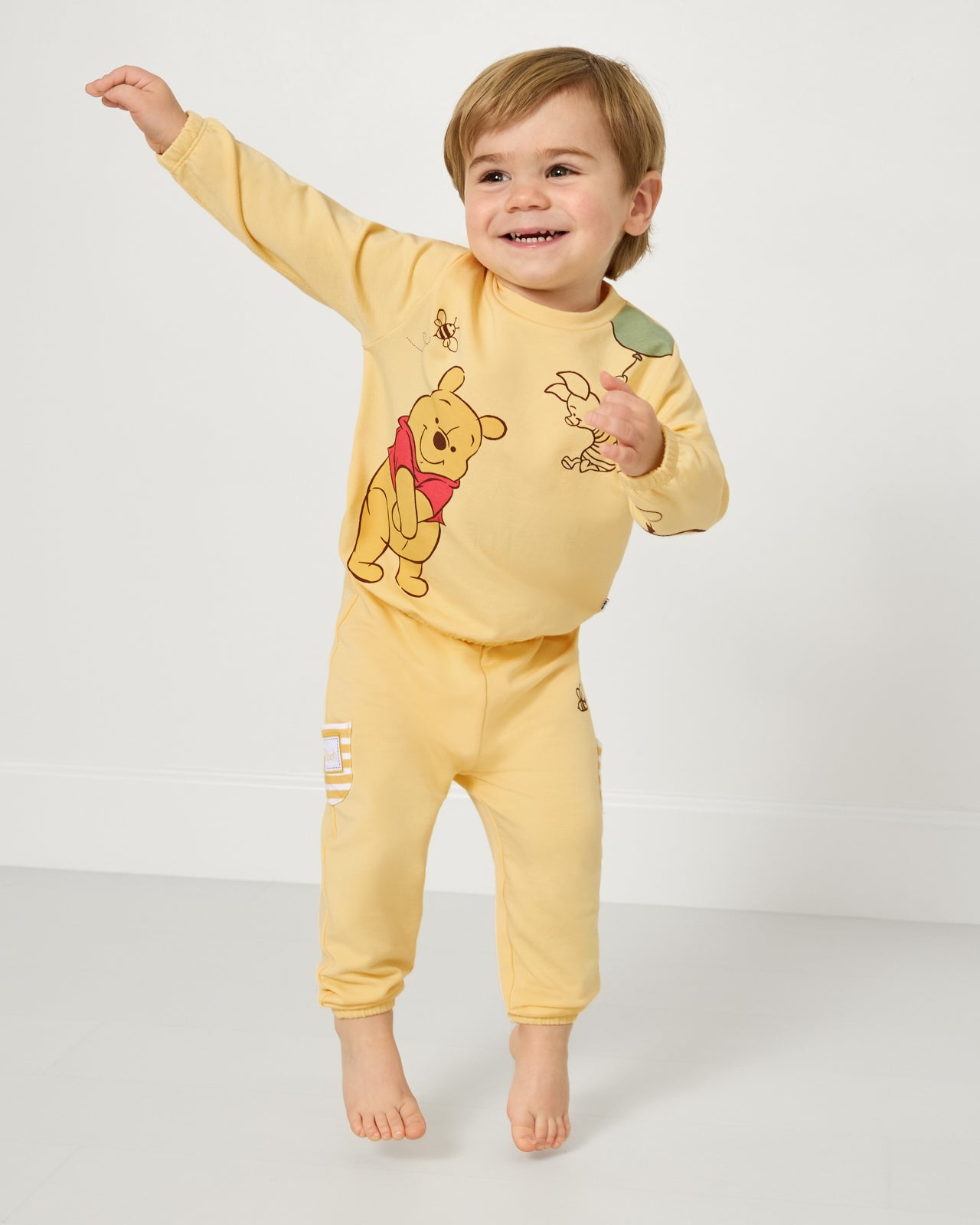 Jumping child wearing the Disney Winnie The Pooh Cinched Jogger and Crewneck Sweatshirt